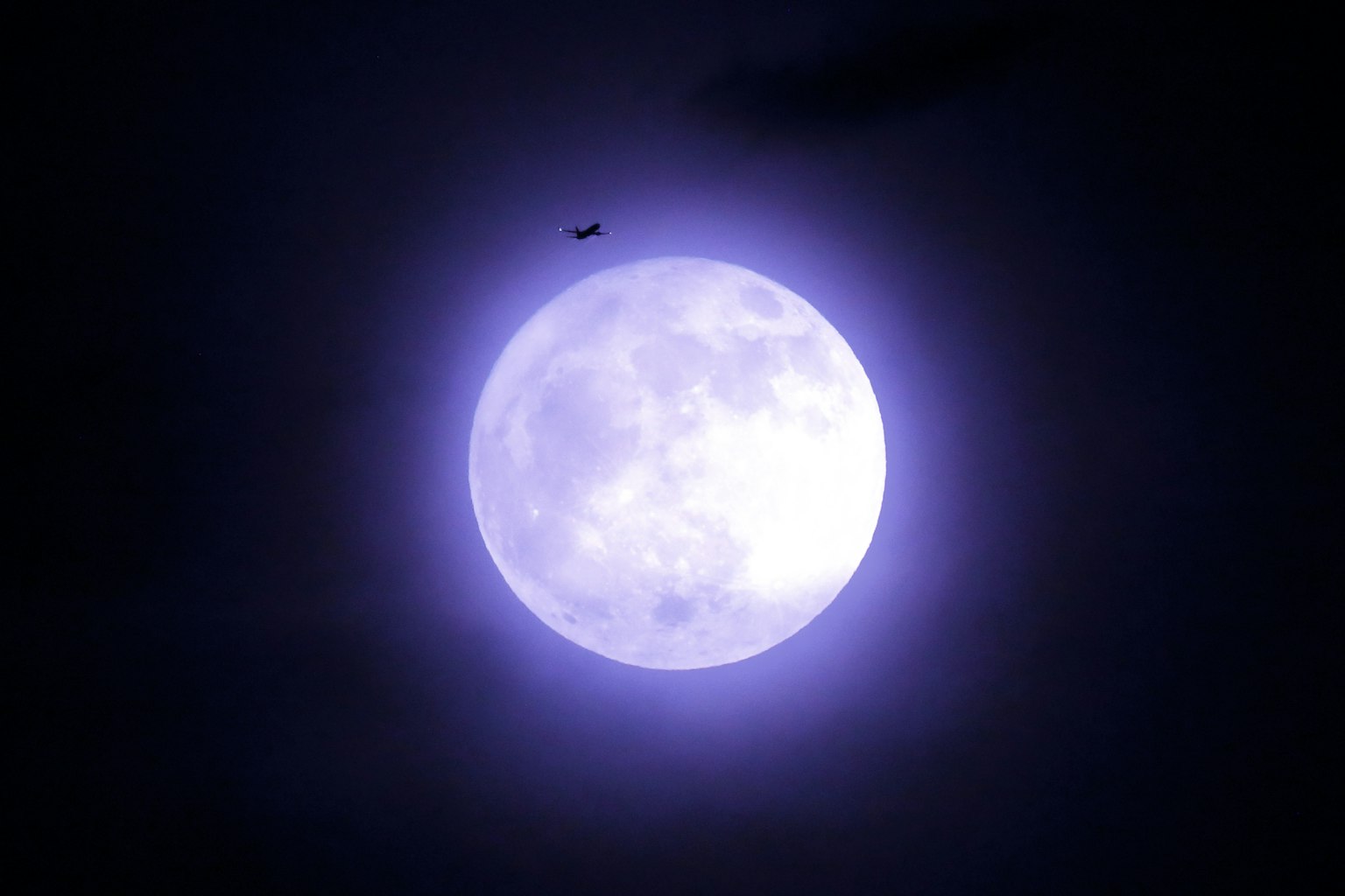 Luna viola con un piccolo oggetto nel cielo notturno