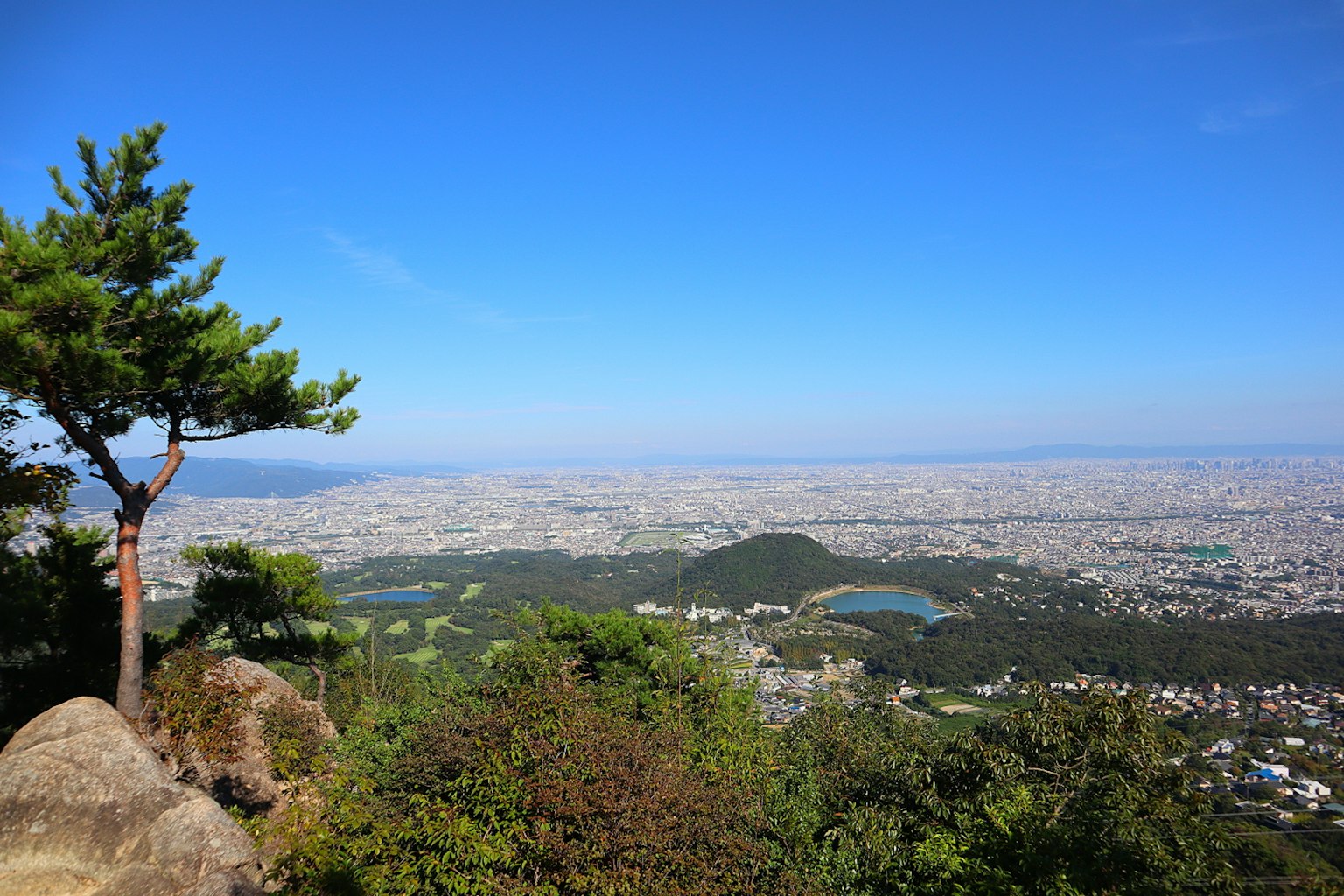 Vista panorámica de una ciudad desde la cima de una montaña con cielo azul