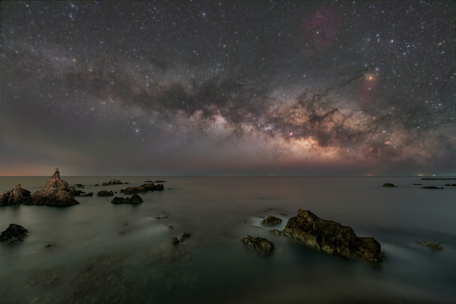 Ciel nocturne magnifique sur le rivage rocheux avec la Voie lactée visible