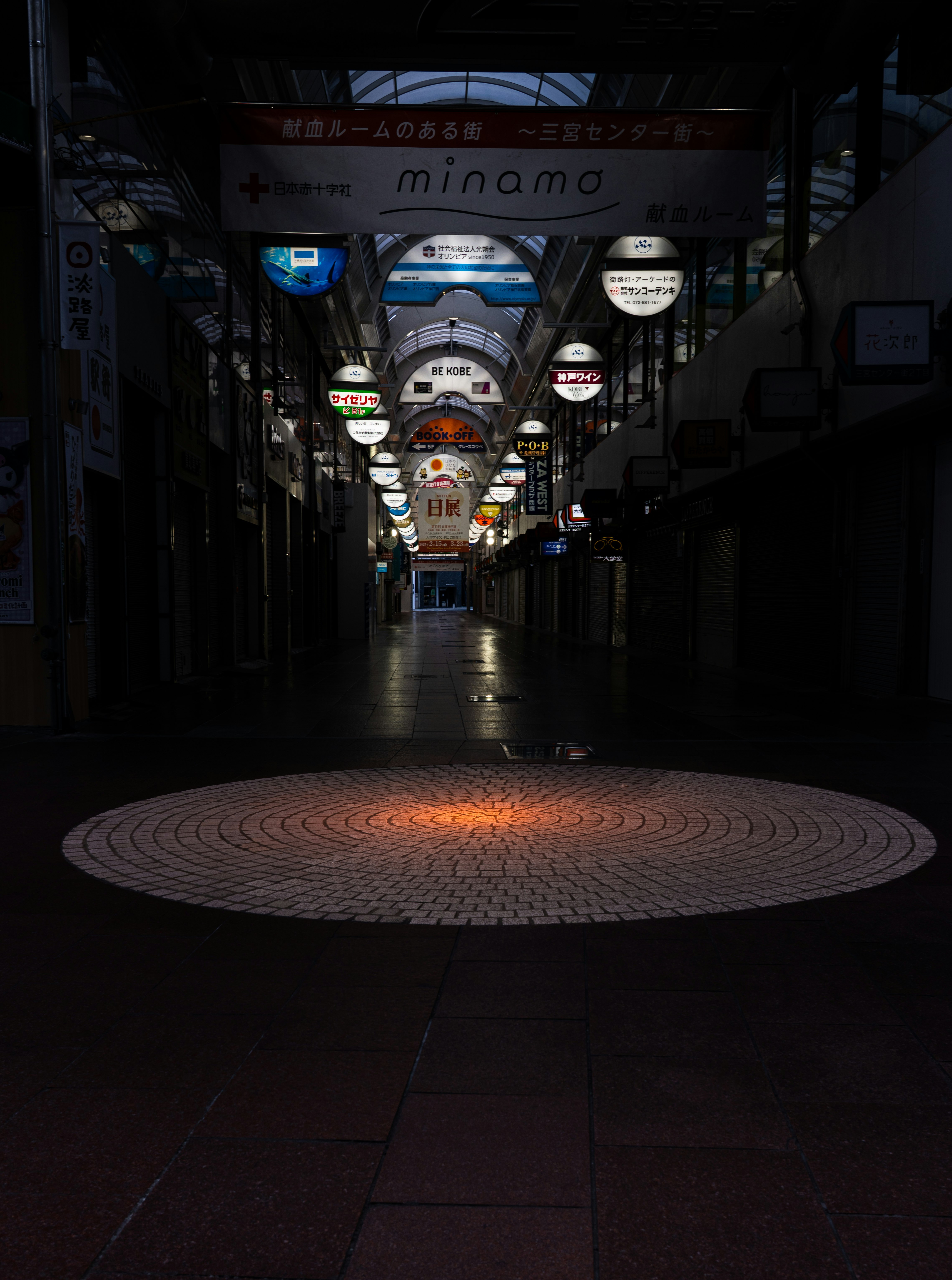 夜の路地に並ぶ看板と照明のある小さな通路
