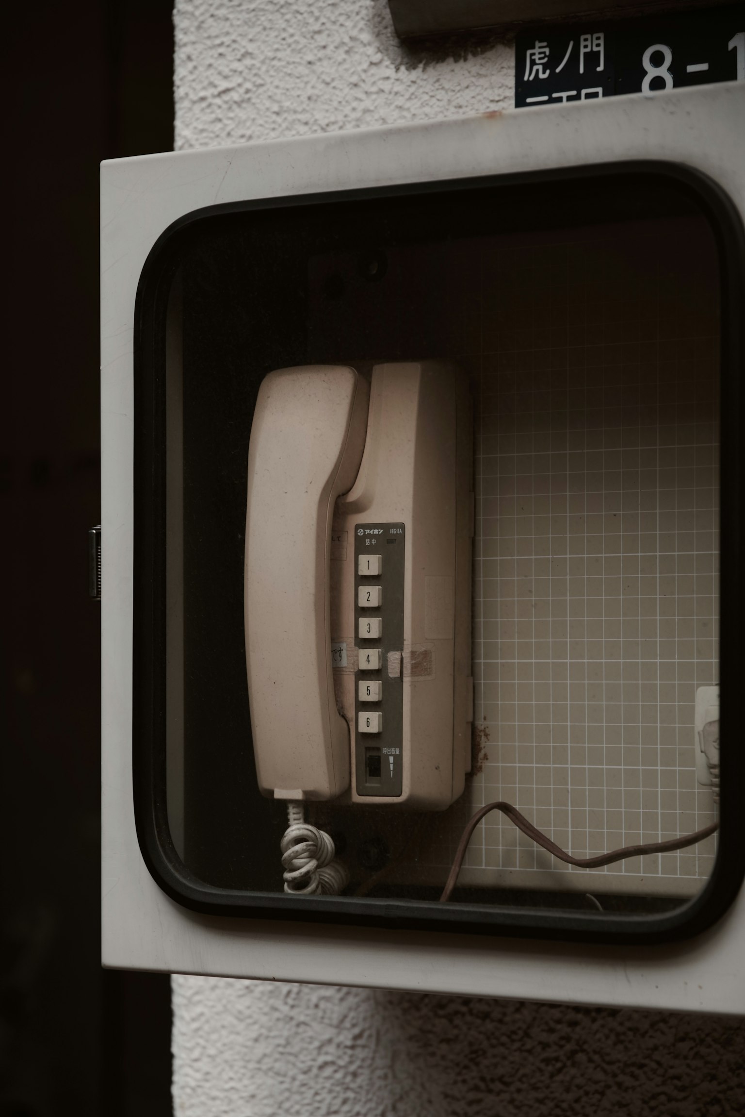 โทรศัพท์สาธารณะเก่าในตู้โทรศัพท์ที่มีการออกแบบย้อนยุค