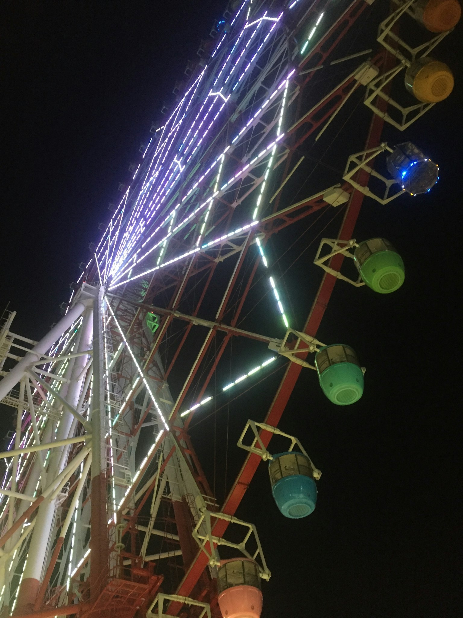 Grande roue colorée illuminée la nuit
