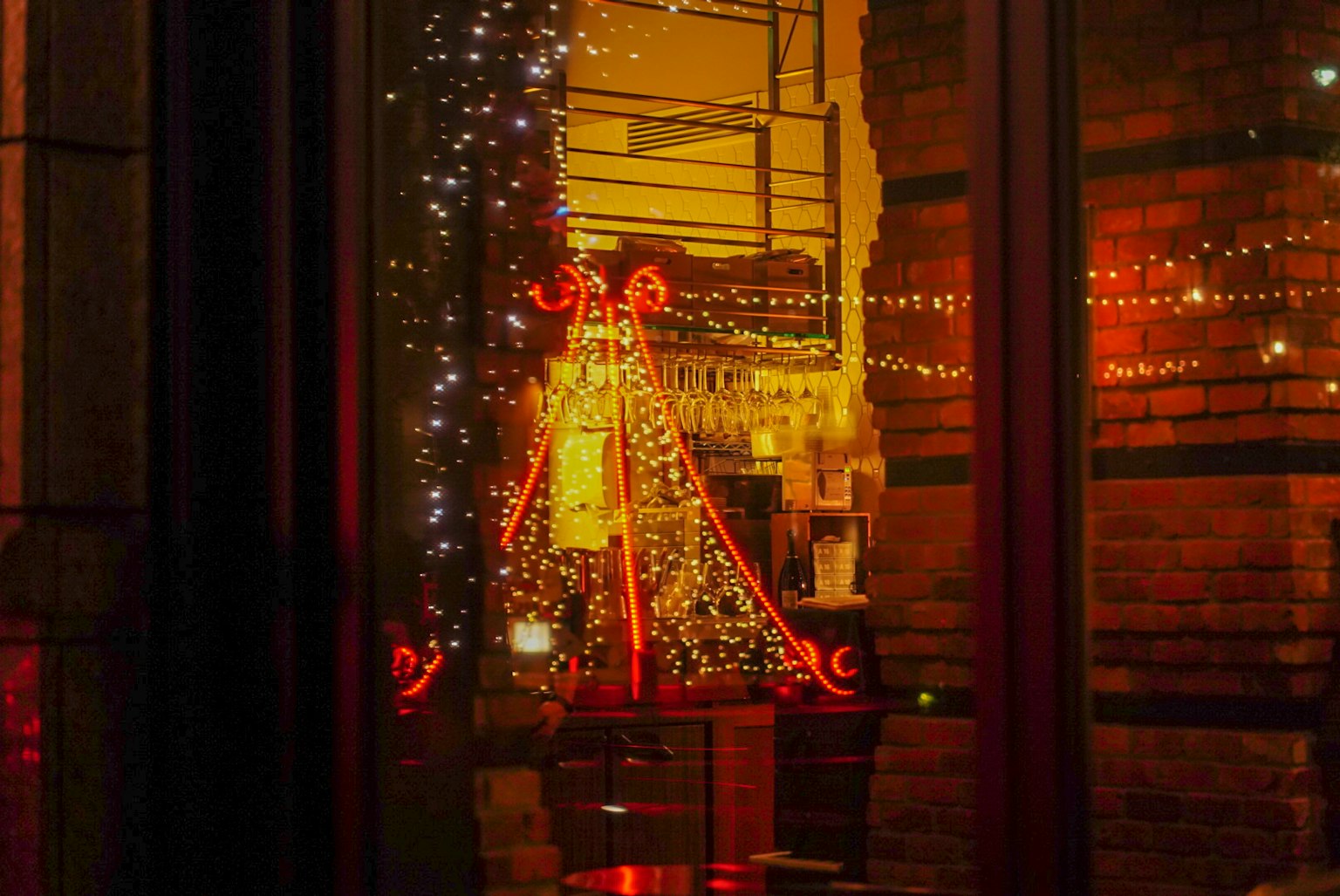 Christmas tree lights and decorations seen through a window