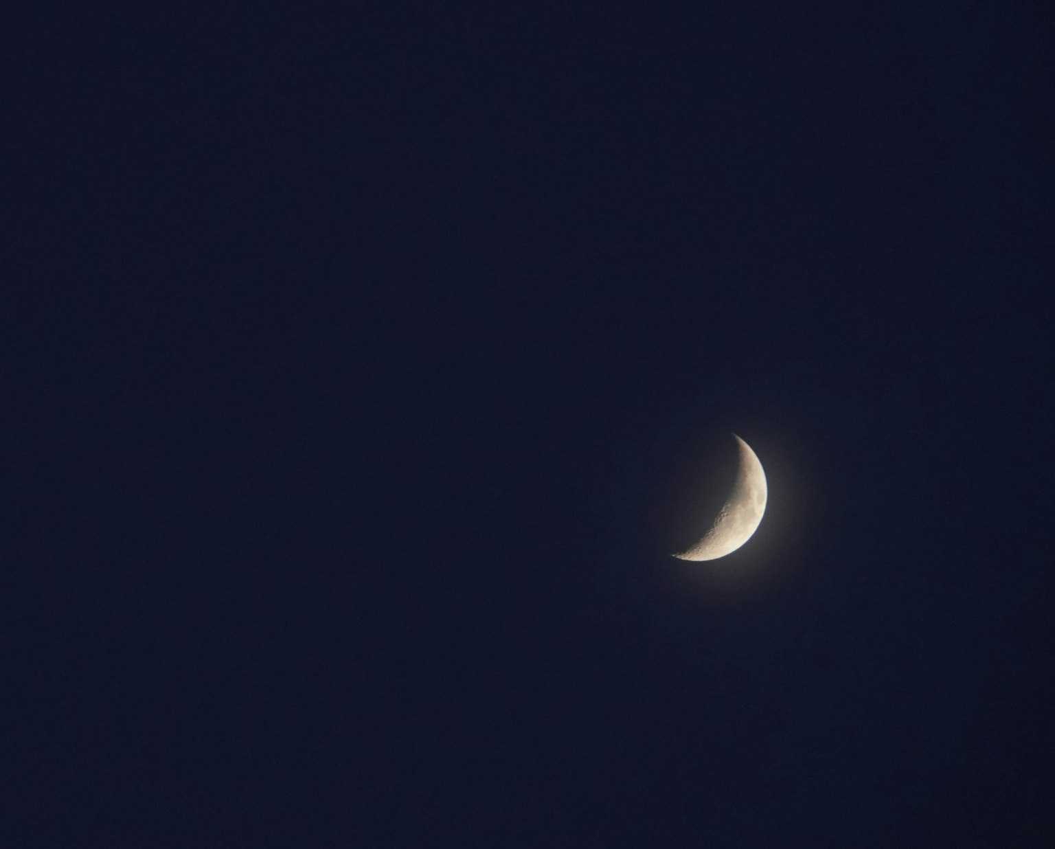Un croissant de lune mince dans un ciel sombre