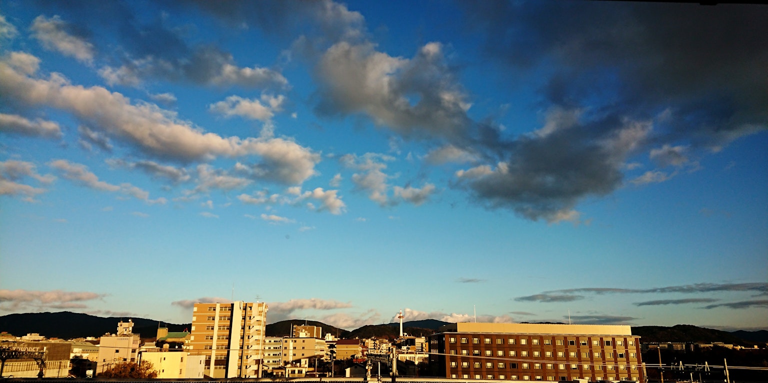 Paesaggio urbano con cielo blu e nuvole edifici in primo piano
