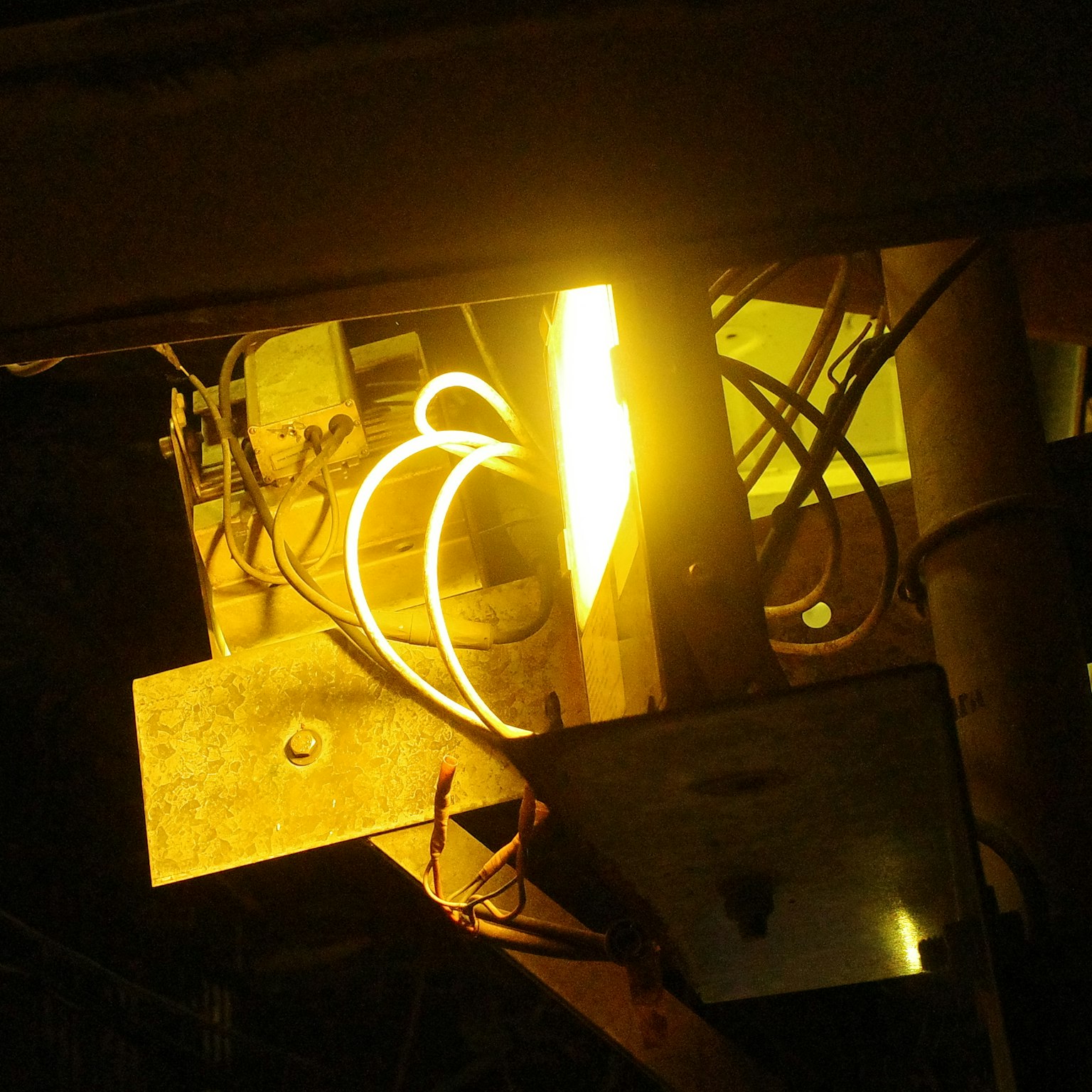 黄色い光と電線が見える機械の内部