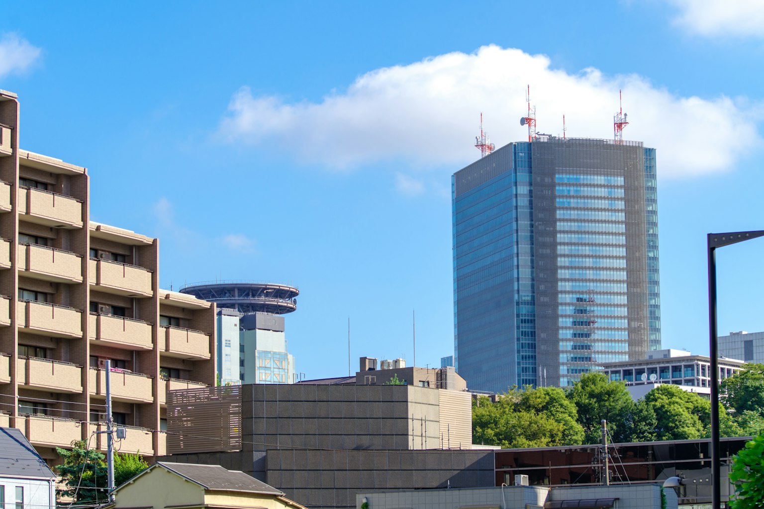 Cityscape featuring tall buildings and low-rise structures under a blue sky
