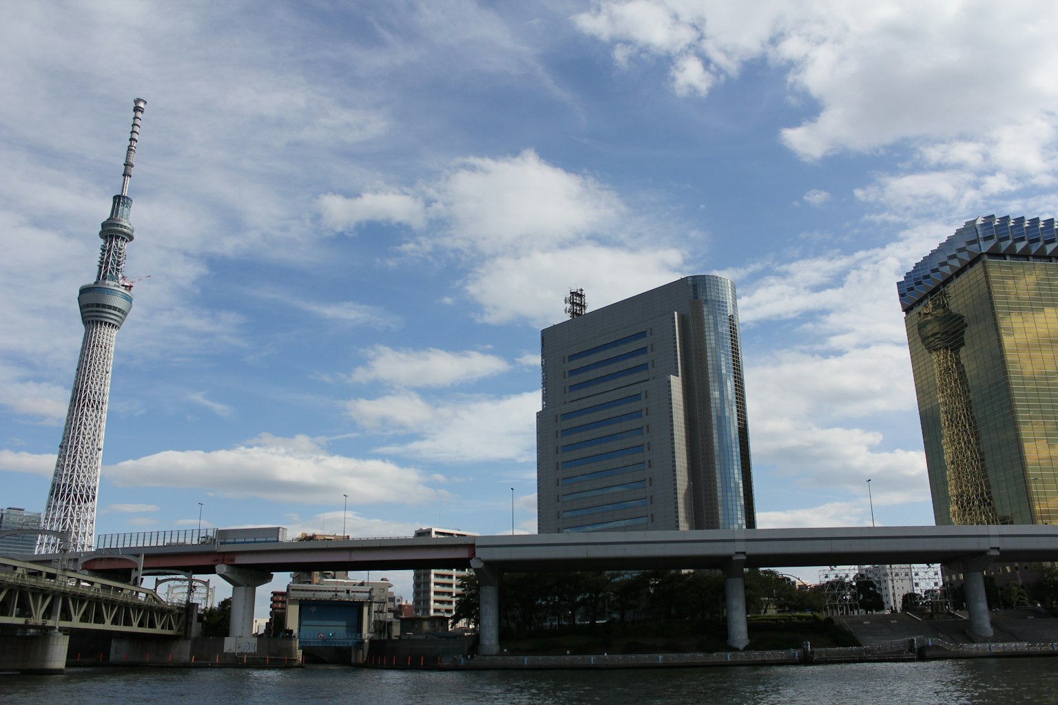 Tokyo Skytree y edificios junto al río bajo un cielo azul