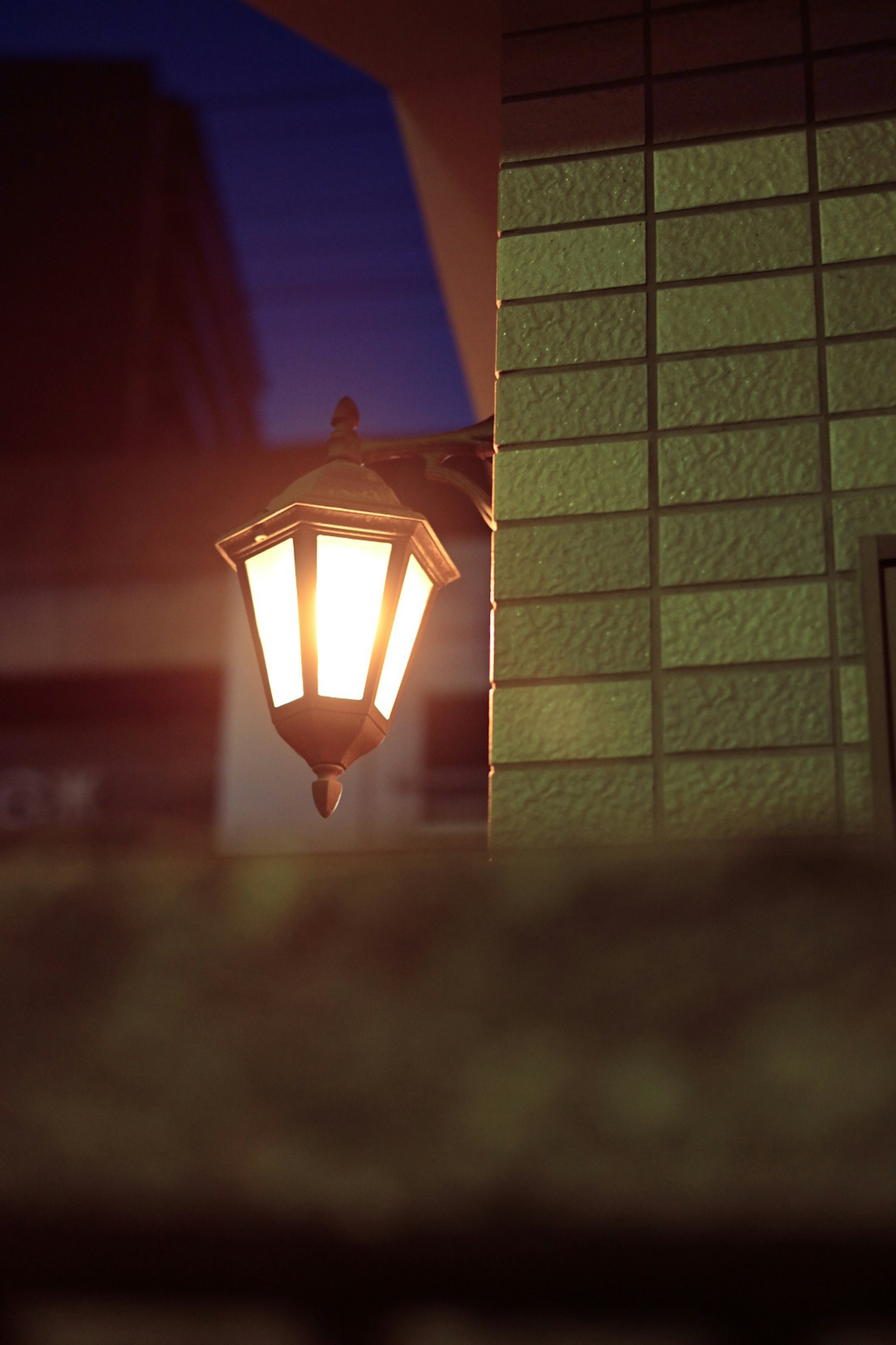 Photo d'un lampadaire émettant une lumière chaude sur un coin de rue faiblement éclairé