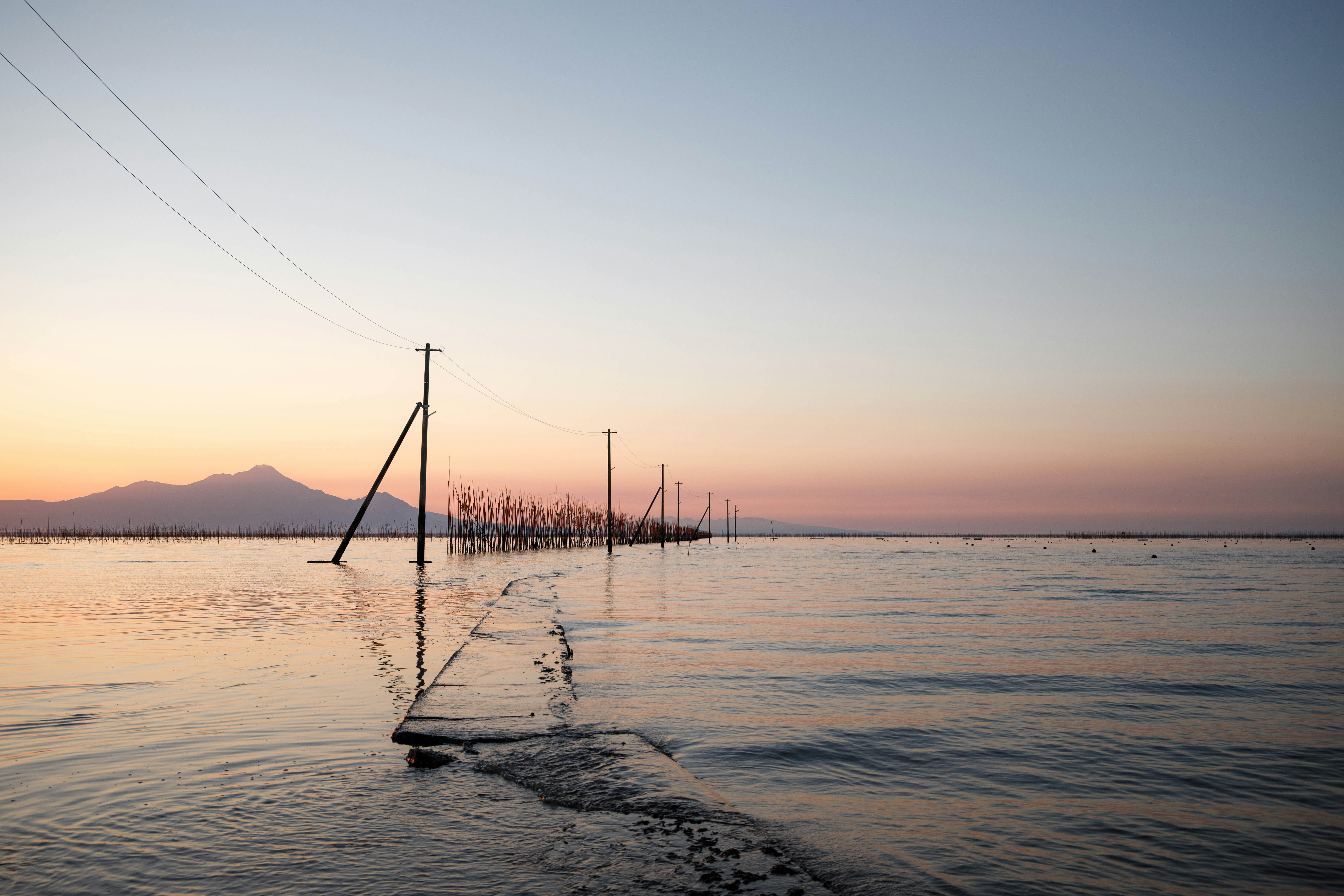 夕焼けの海に突き出す桟橋と静かな波
