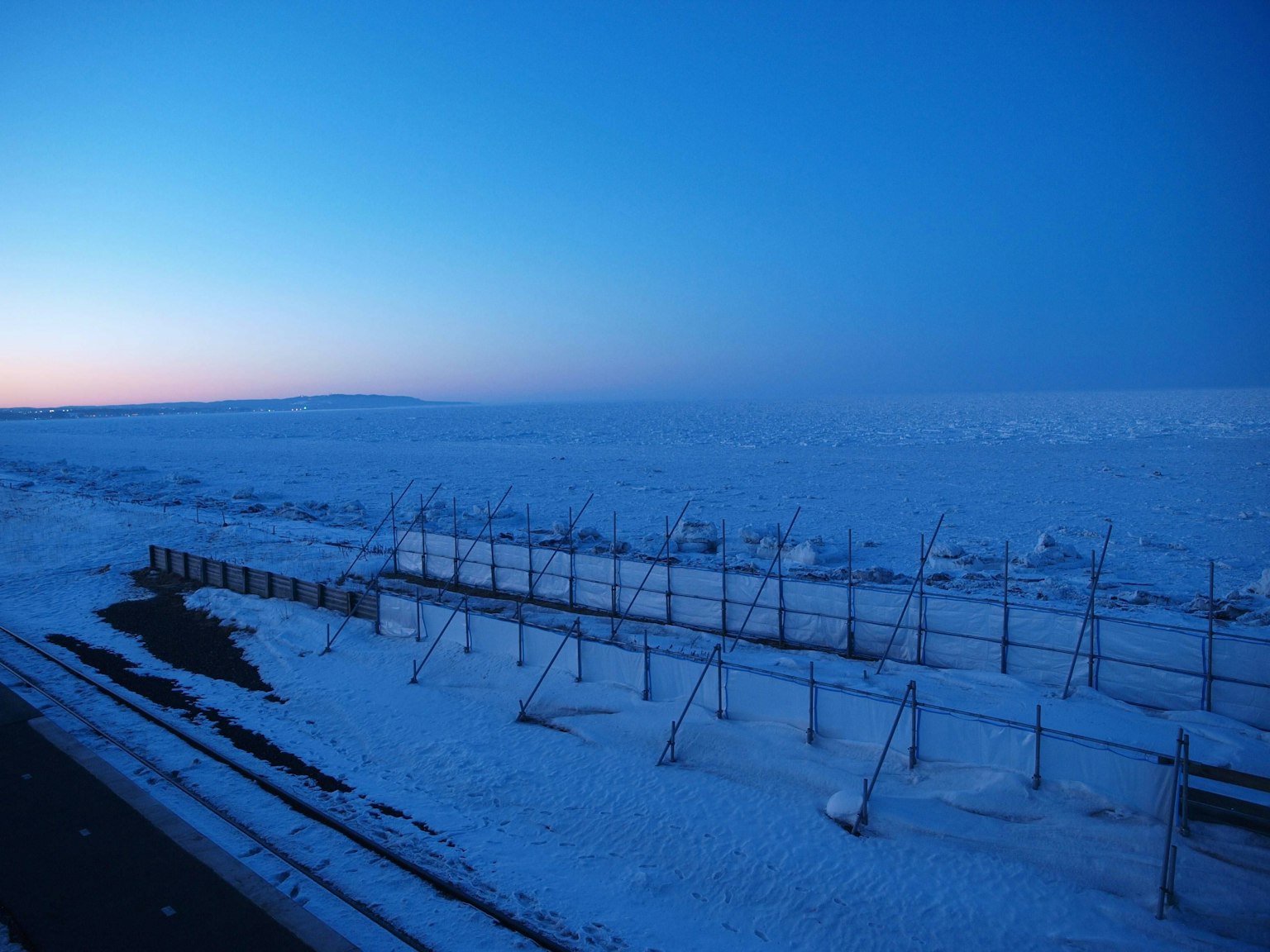 Vaste paysage enneigé sous un ciel bleu au crépuscule