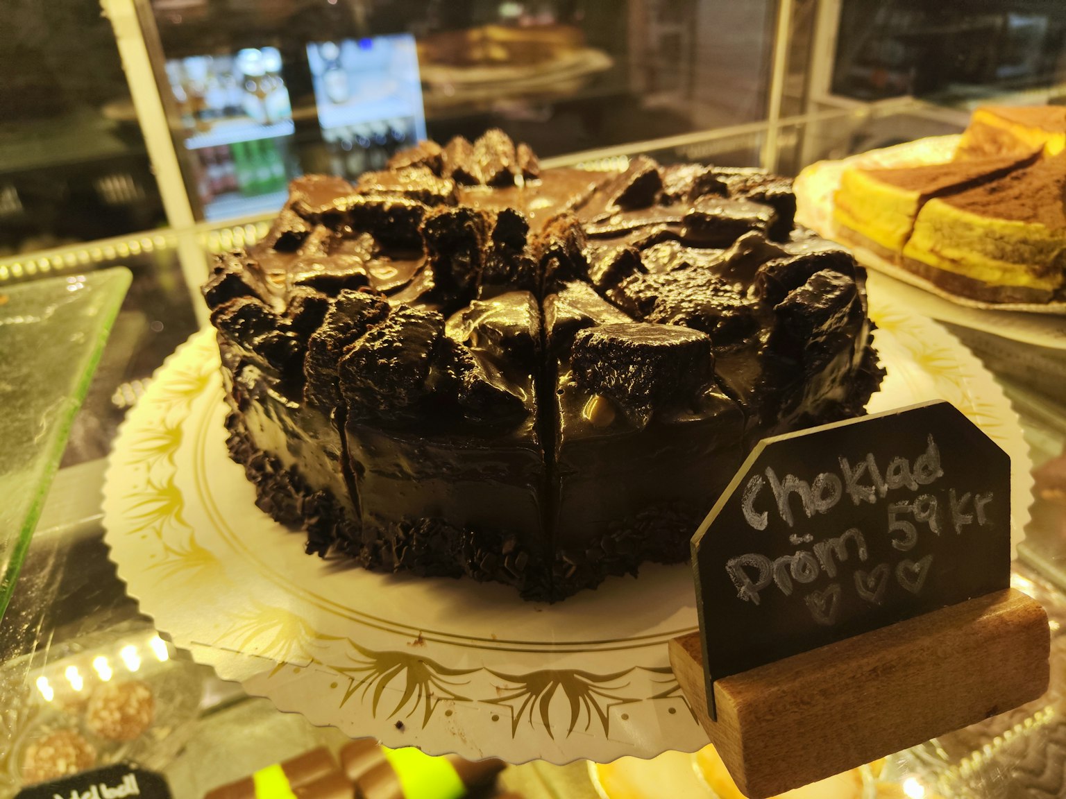 Gâteau au chocolat surmonté de biscuits Oreo exposé dans une vitrine