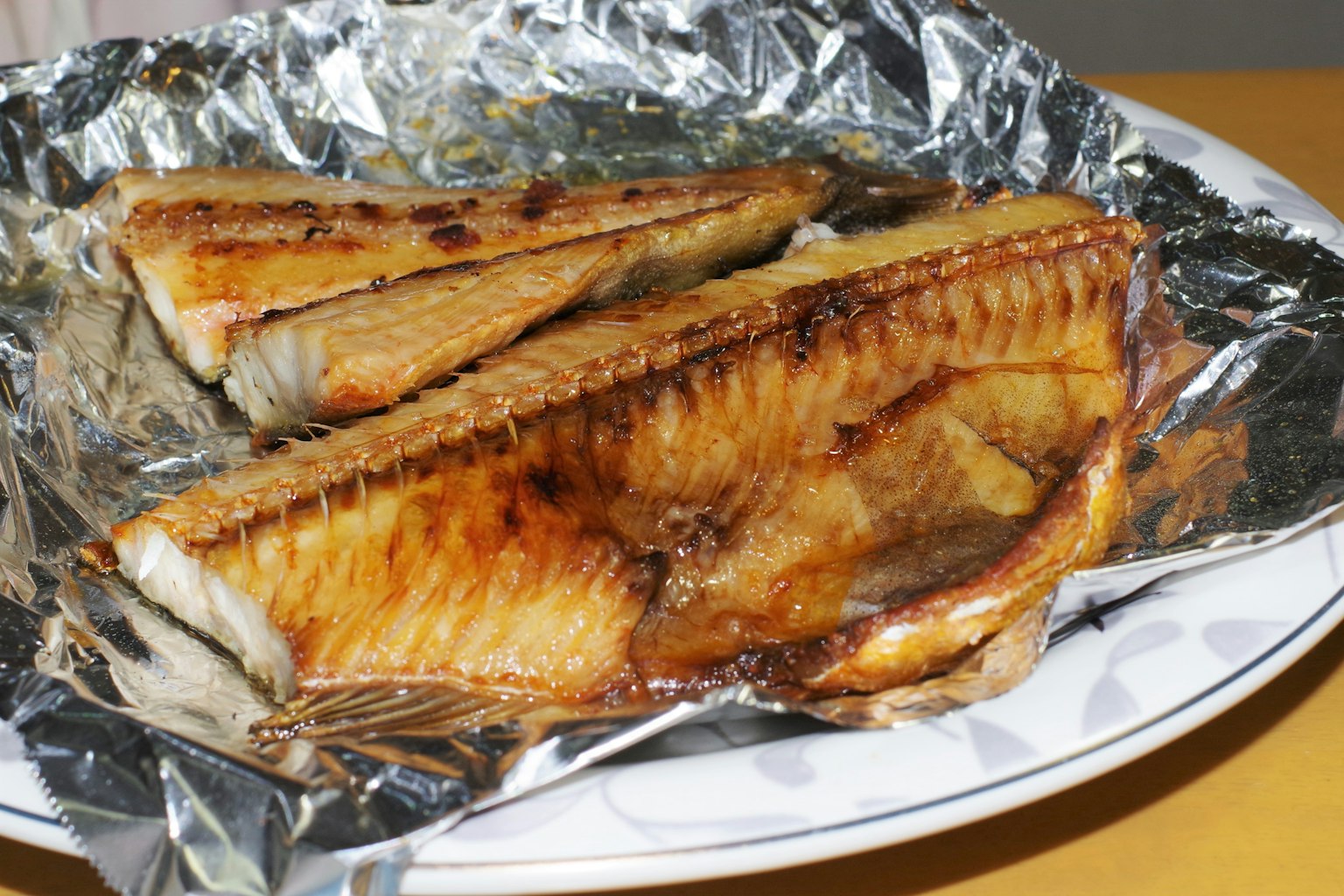 Filets de poisson grillés servis dans une assiette avec du papier d'aluminium