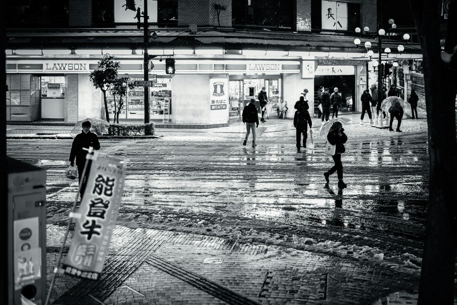 Night scene with pedestrians and wet pavement