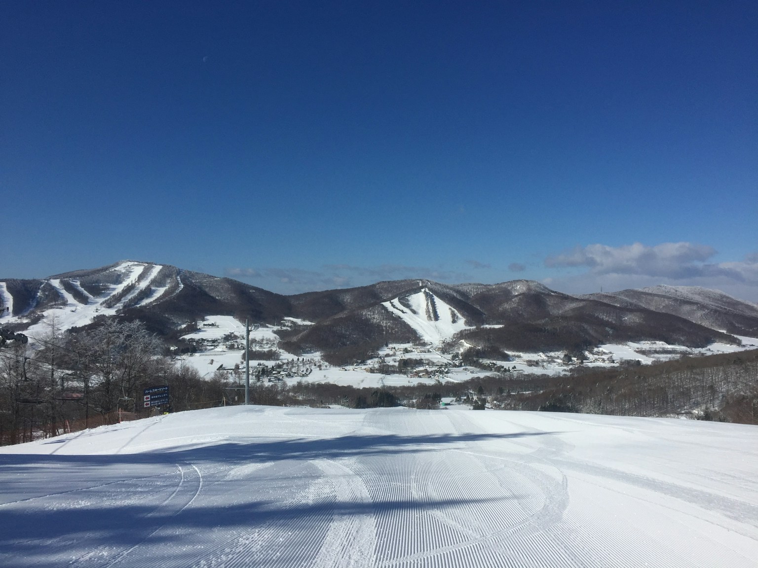 Paisaje de estación de esquí cubierto de nieve con cielo azul y montañas