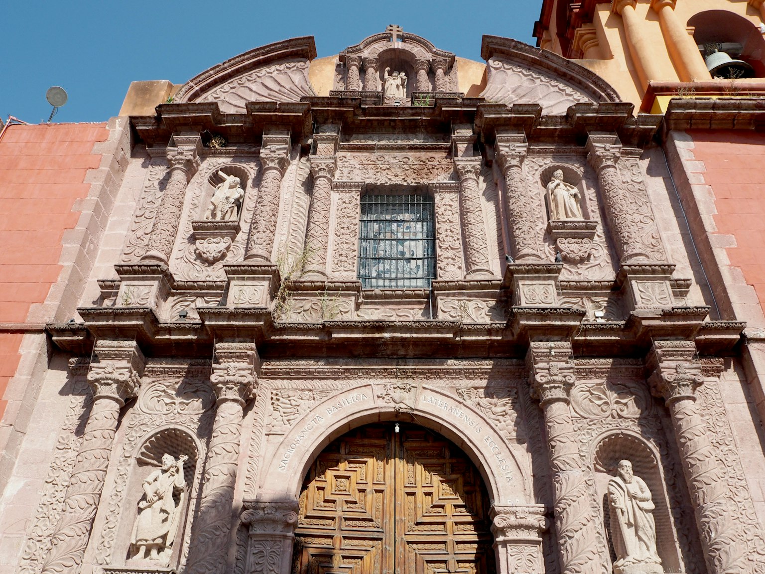 Facciata di chiesa storica con sculture intricate e porte in legno