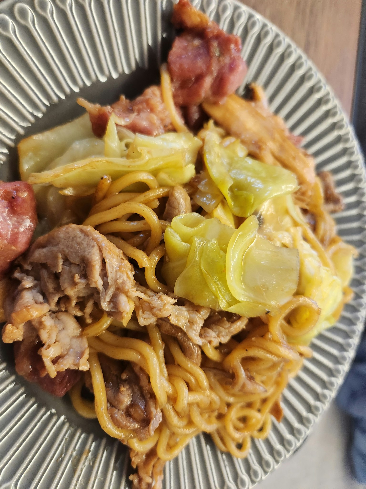 盤子裡的炒麵配肉和高麗菜
