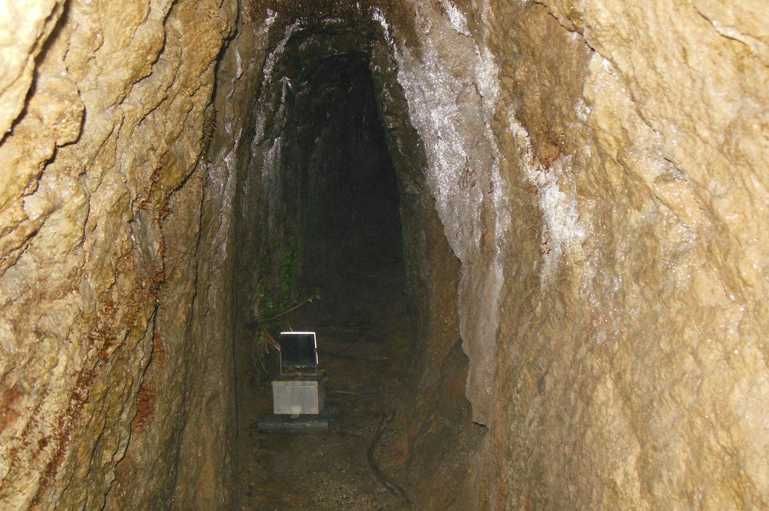 Un tunnel buio con una scatola bianca in fondo