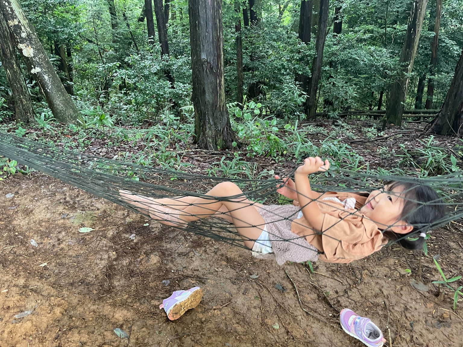 一个女孩躺在森林中的网里