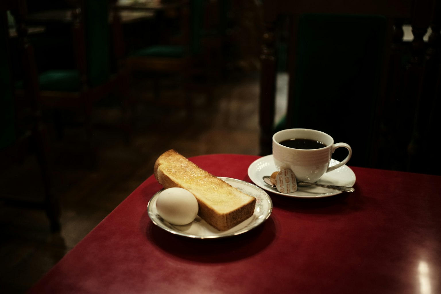Kopi, roti panggang, dan telur rebus di atas meja