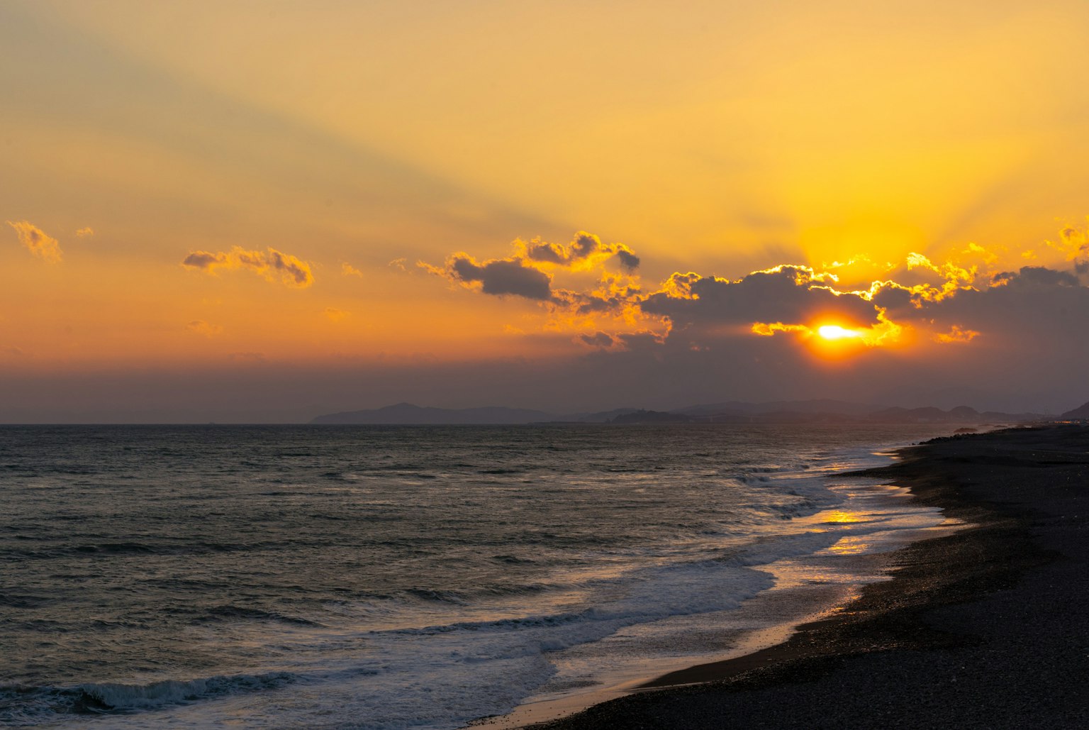 Hermoso atardecer sobre el océano con olas y nubes