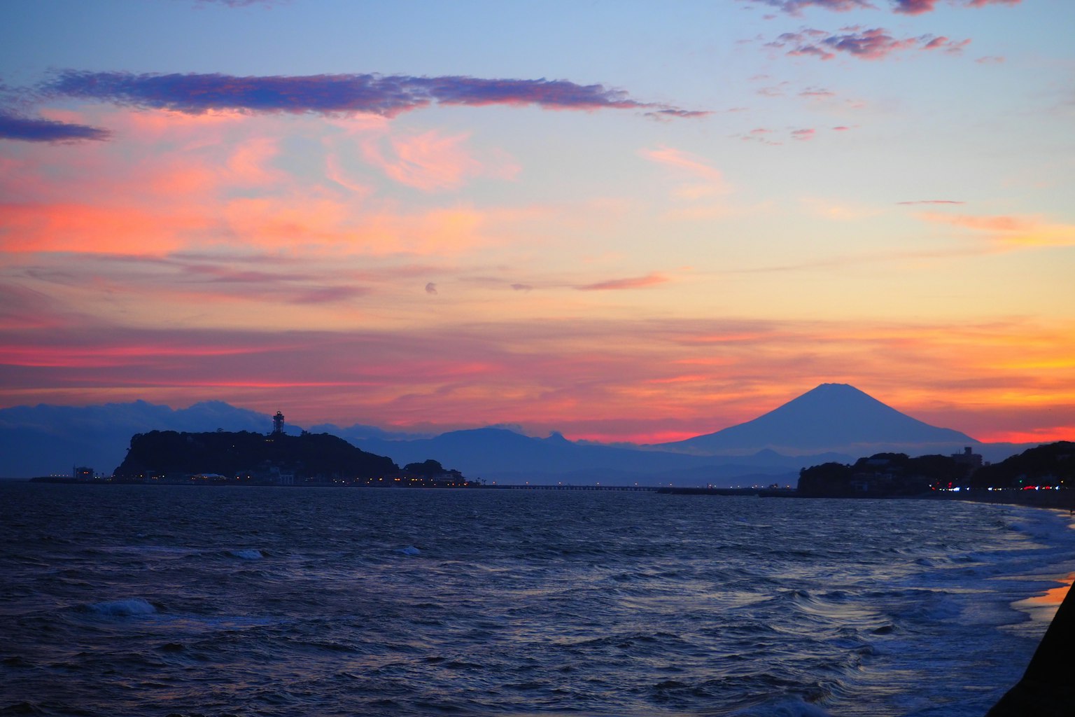 Vista del tramonto con il monte Fuji e l'oceano
