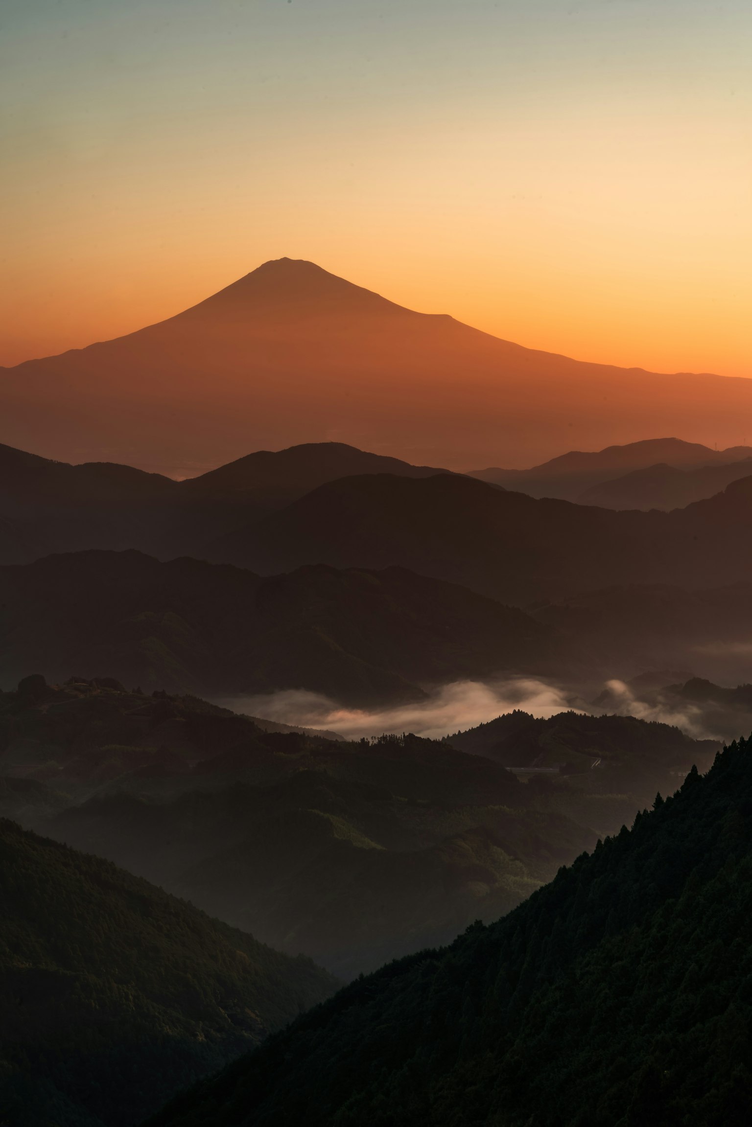 Silhouette delle montagne con un bel cielo arancione al tramonto Monte Fuji sullo sfondo
