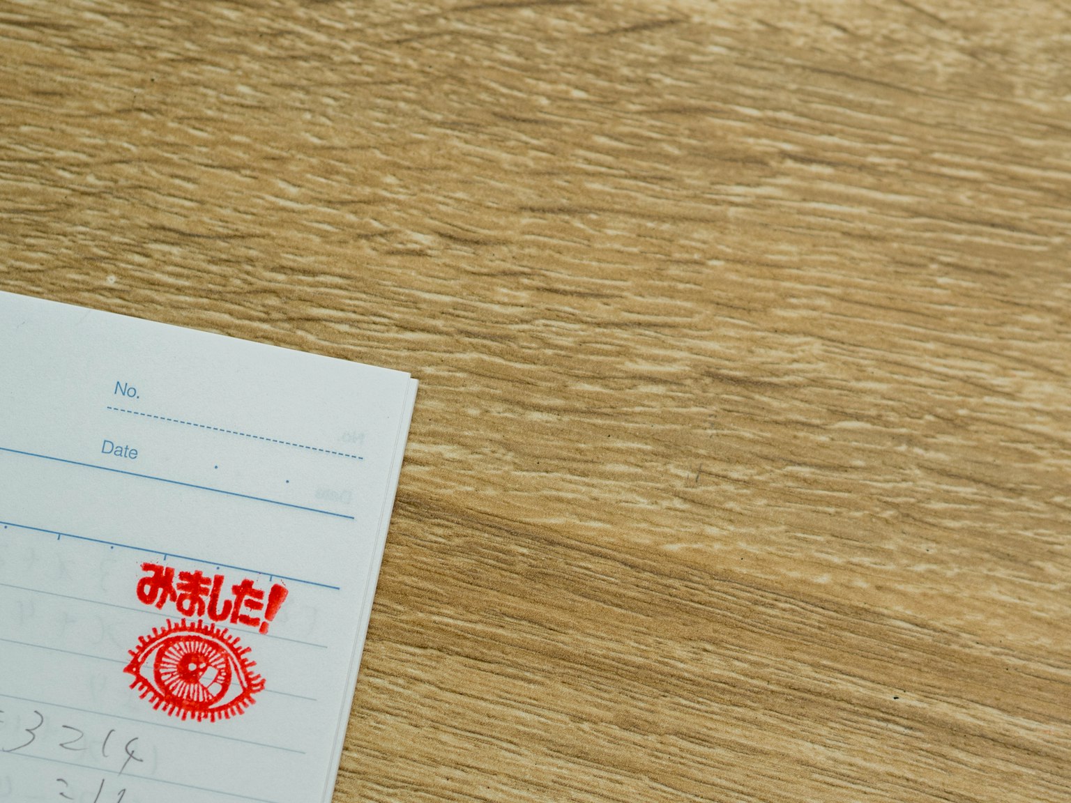 Hoja de memo con un sello japonés sobre un fondo de madera
