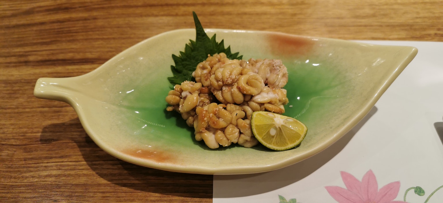 Piatto servito su un piatto a forma di foglia verde con pollo e una fetta di lime