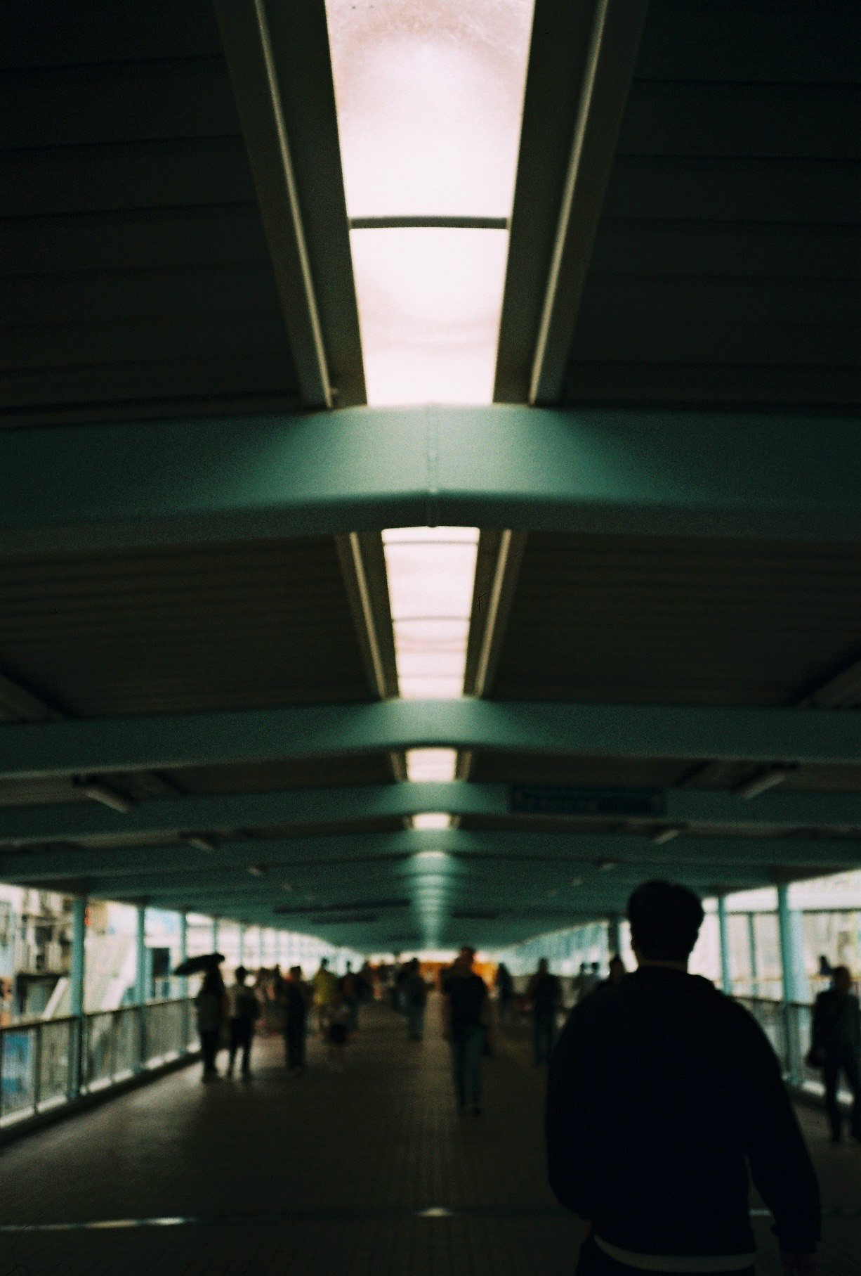rear view of a person walking along a long underpass corridor