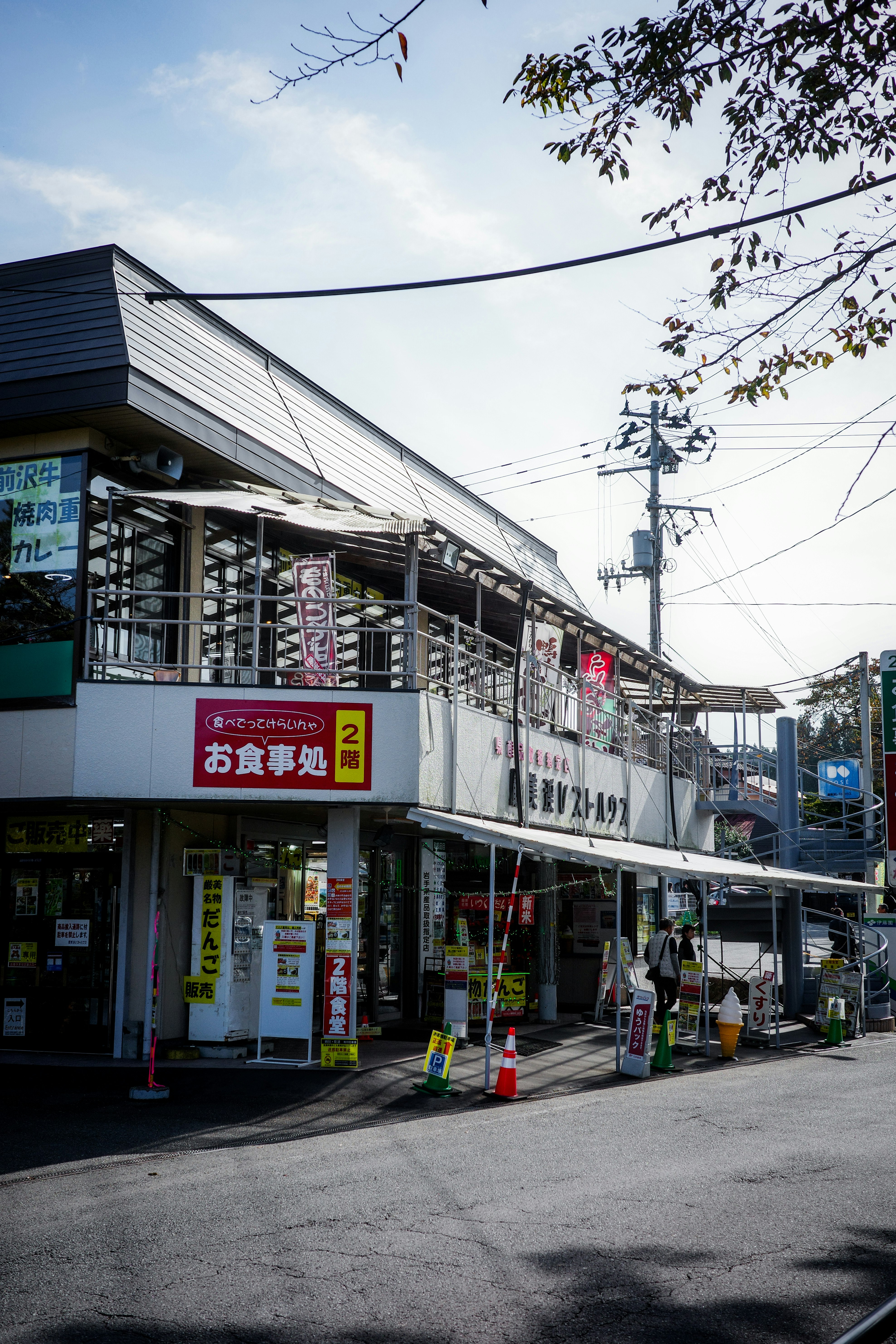 ทัศนียภาพภายนอกของอาคารพาณิชย์พร้อมป้ายร้านใต้ท้องฟ้าสีฟ้า