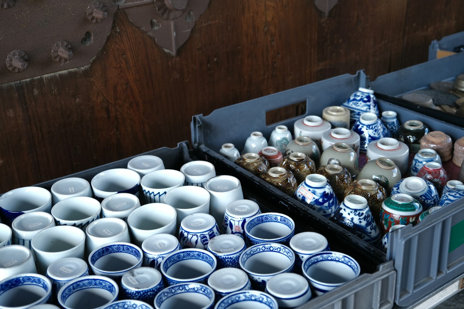 Una collezione di tazze in ceramica con vari design esposte in casse di mercato