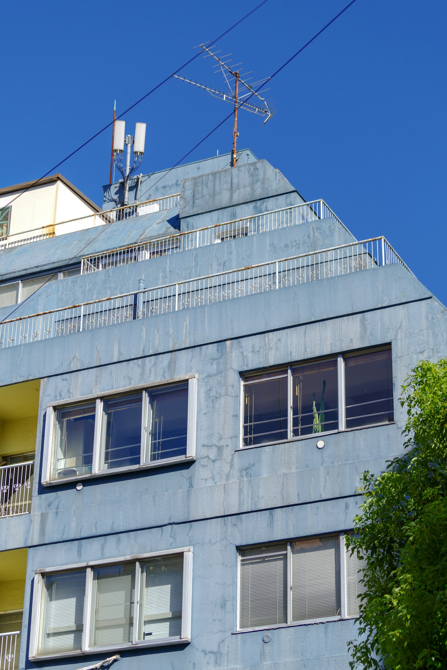 Bâtiment bleu avec des antennes et des fenêtres sur la partie supérieure