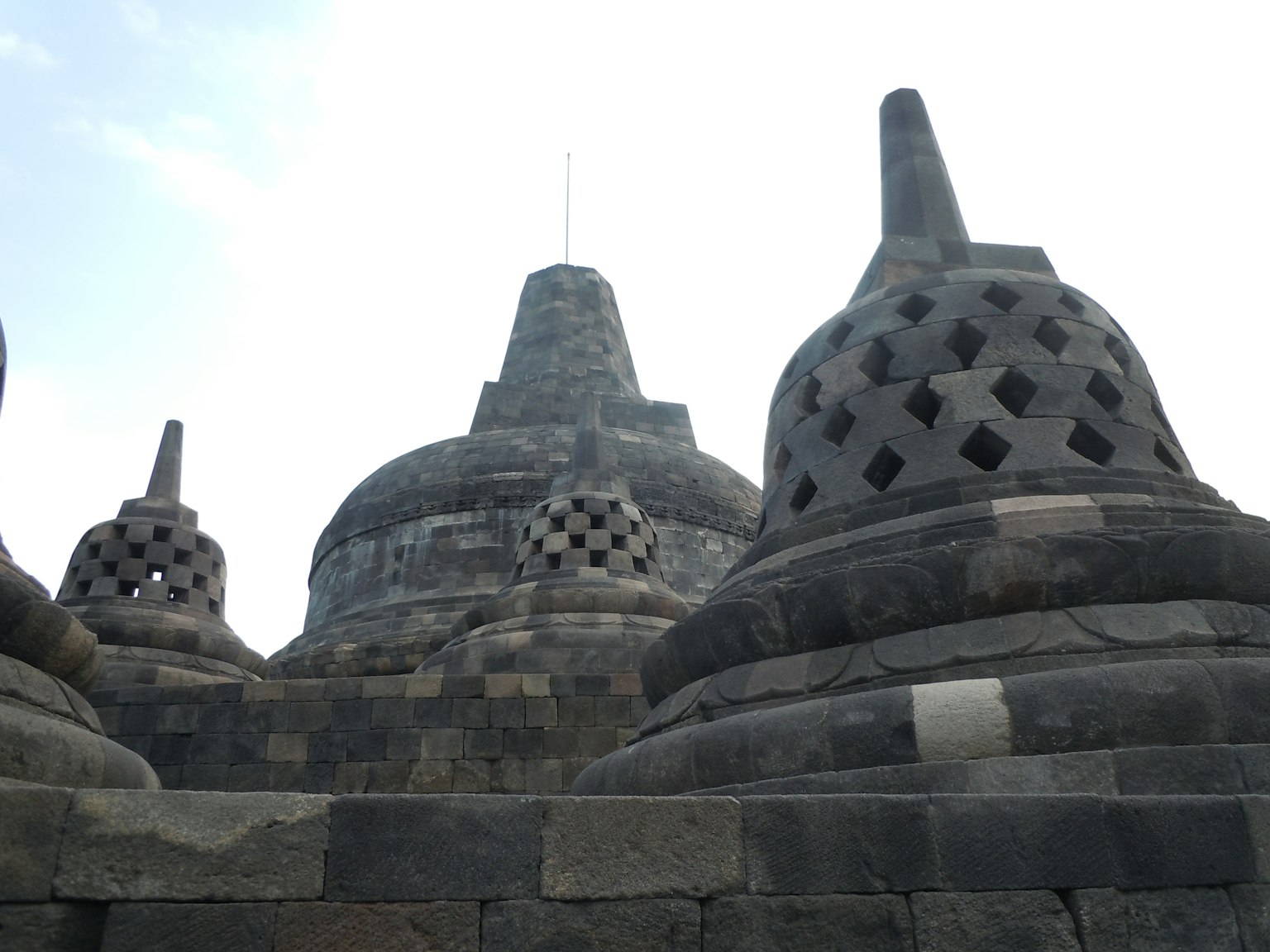 Gros plan des stupas du temple de Borobudur montrant des structures en pierre et des designs perforés
