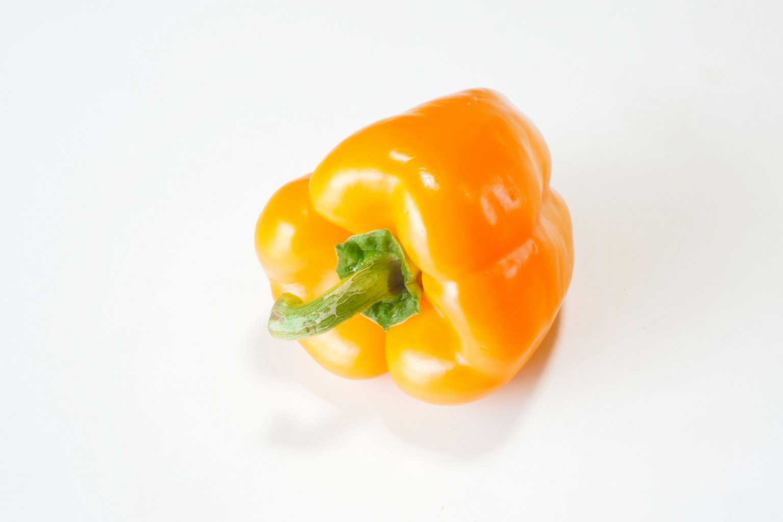 Poivron orange vif placé sur un fond blanc