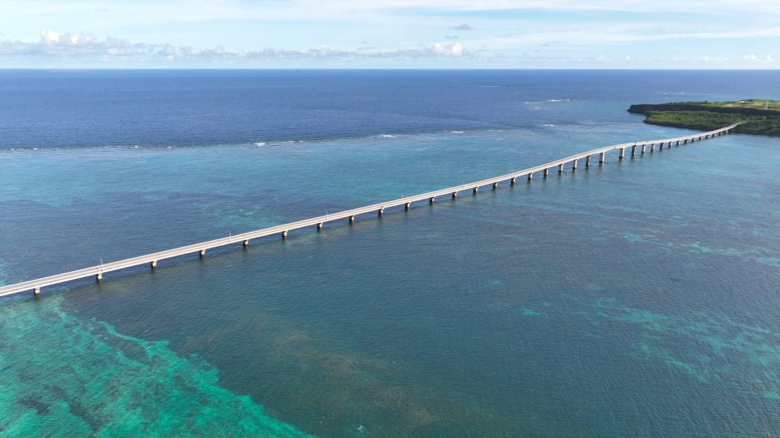 Vista aérea de un largo puente sobre el agua azul del océano