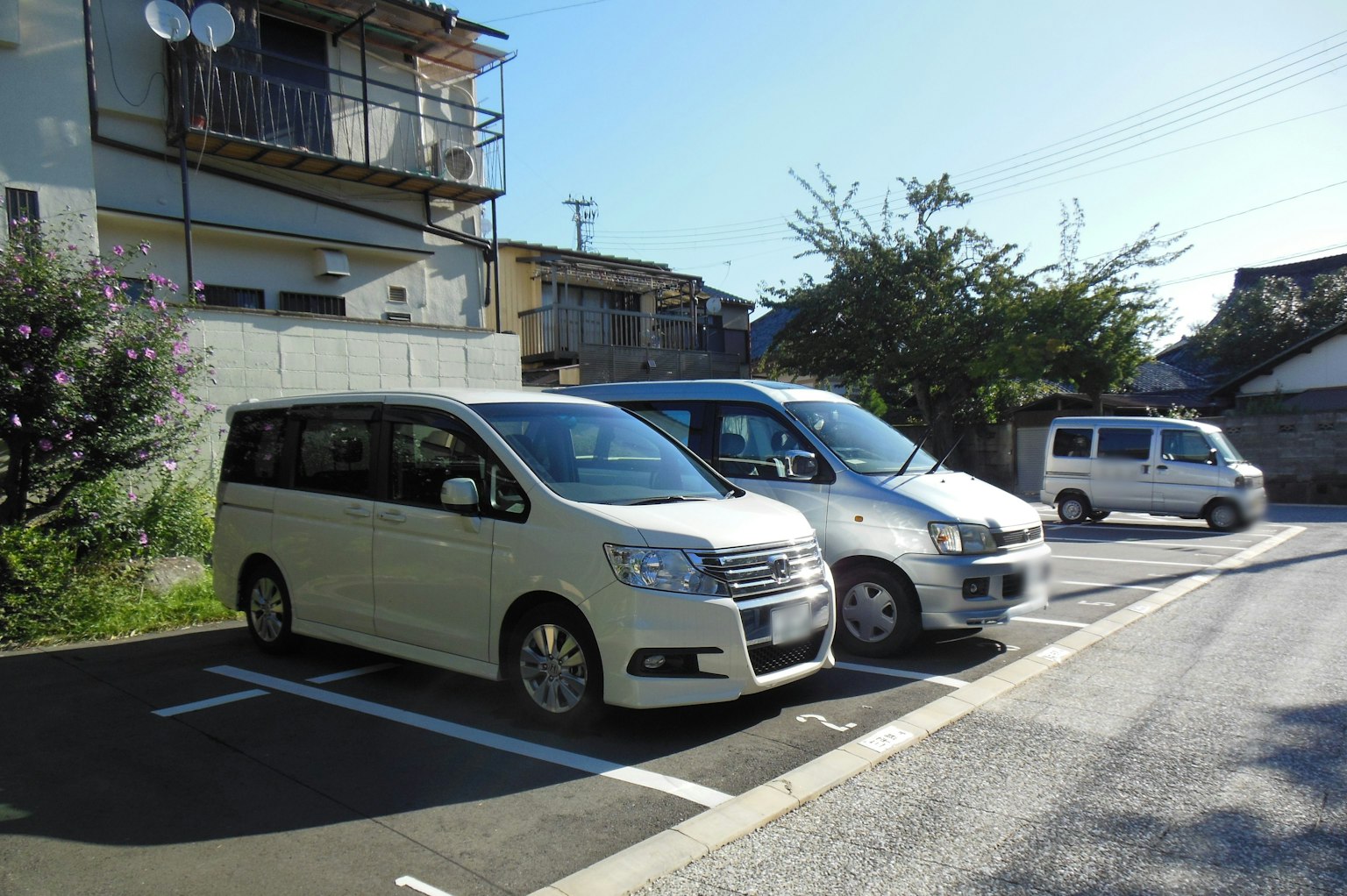 Due auto bianche parcheggiate in un'area vicino a un edificio