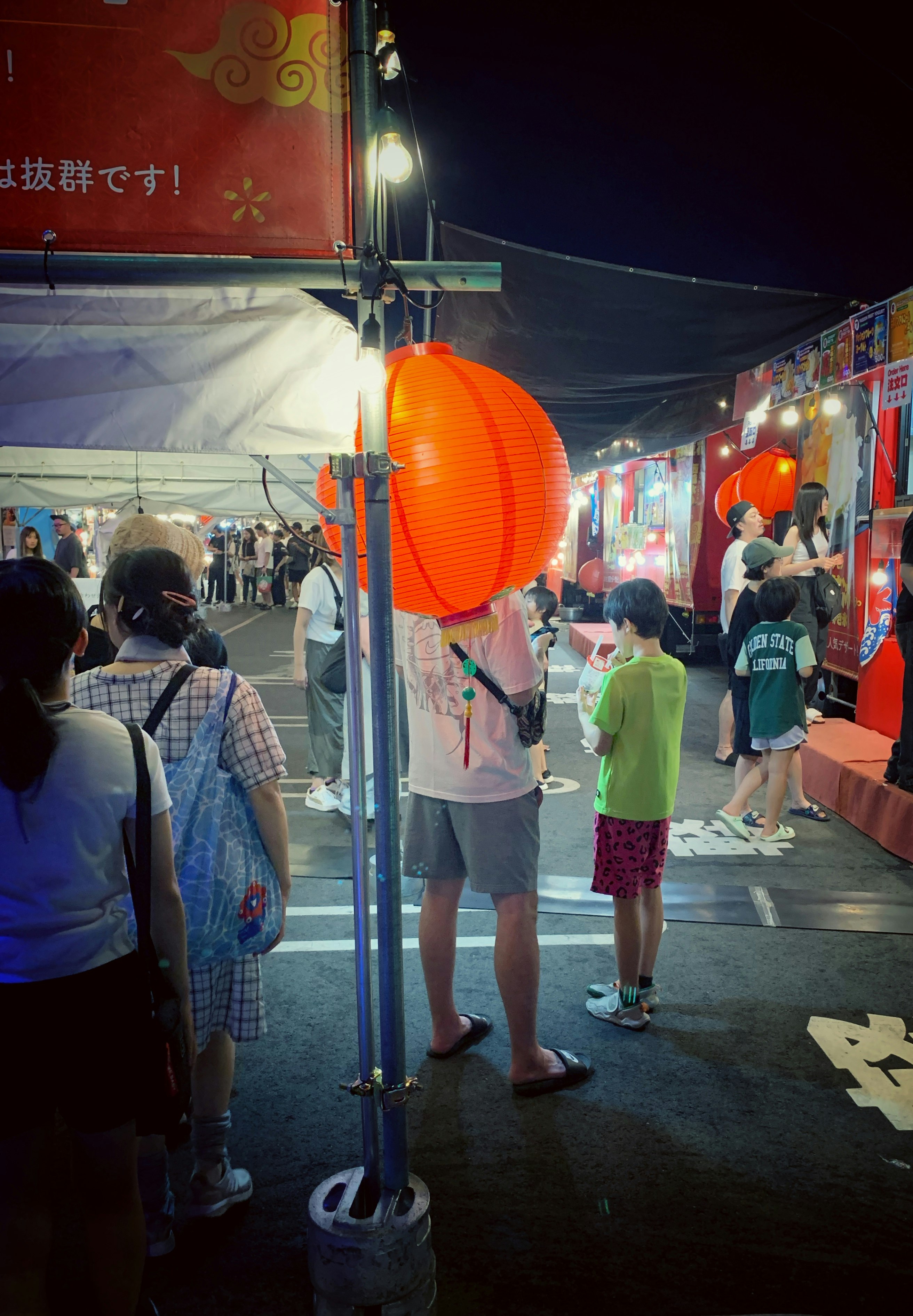夜の屋台通りで提灯が並ぶ夏祭りの雰囲気