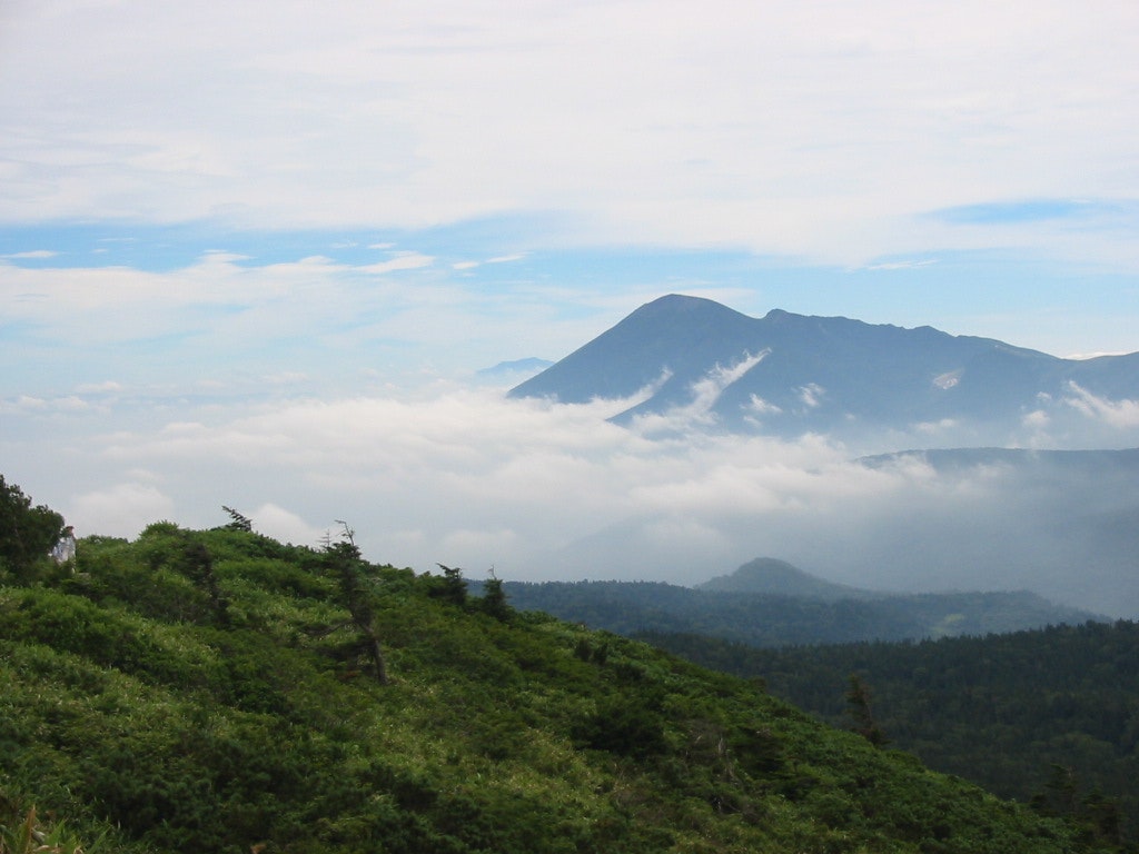 punggungan pegunungan hijau dengan lautan awan