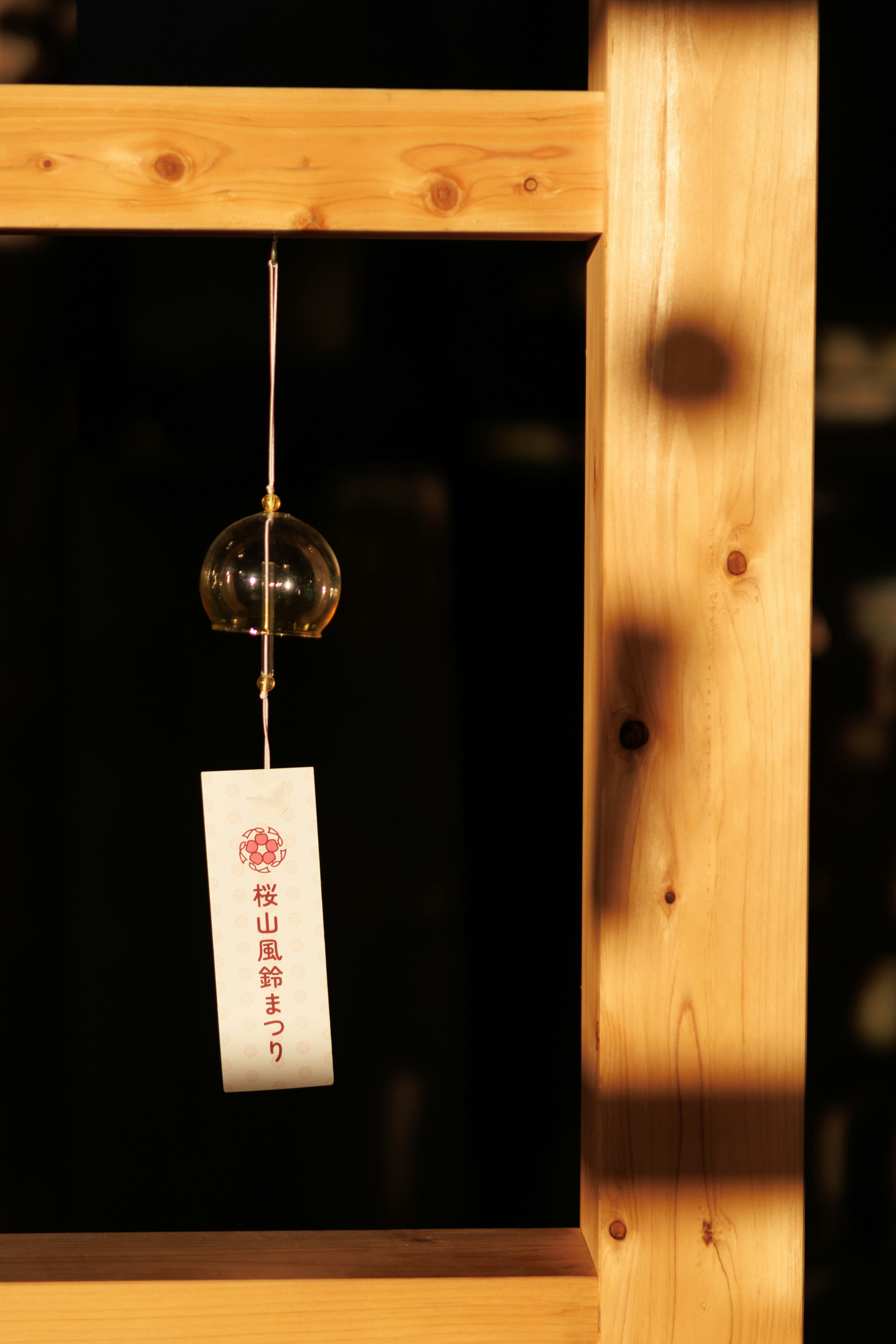 glass lantern and hanging tag by a wooden window frame