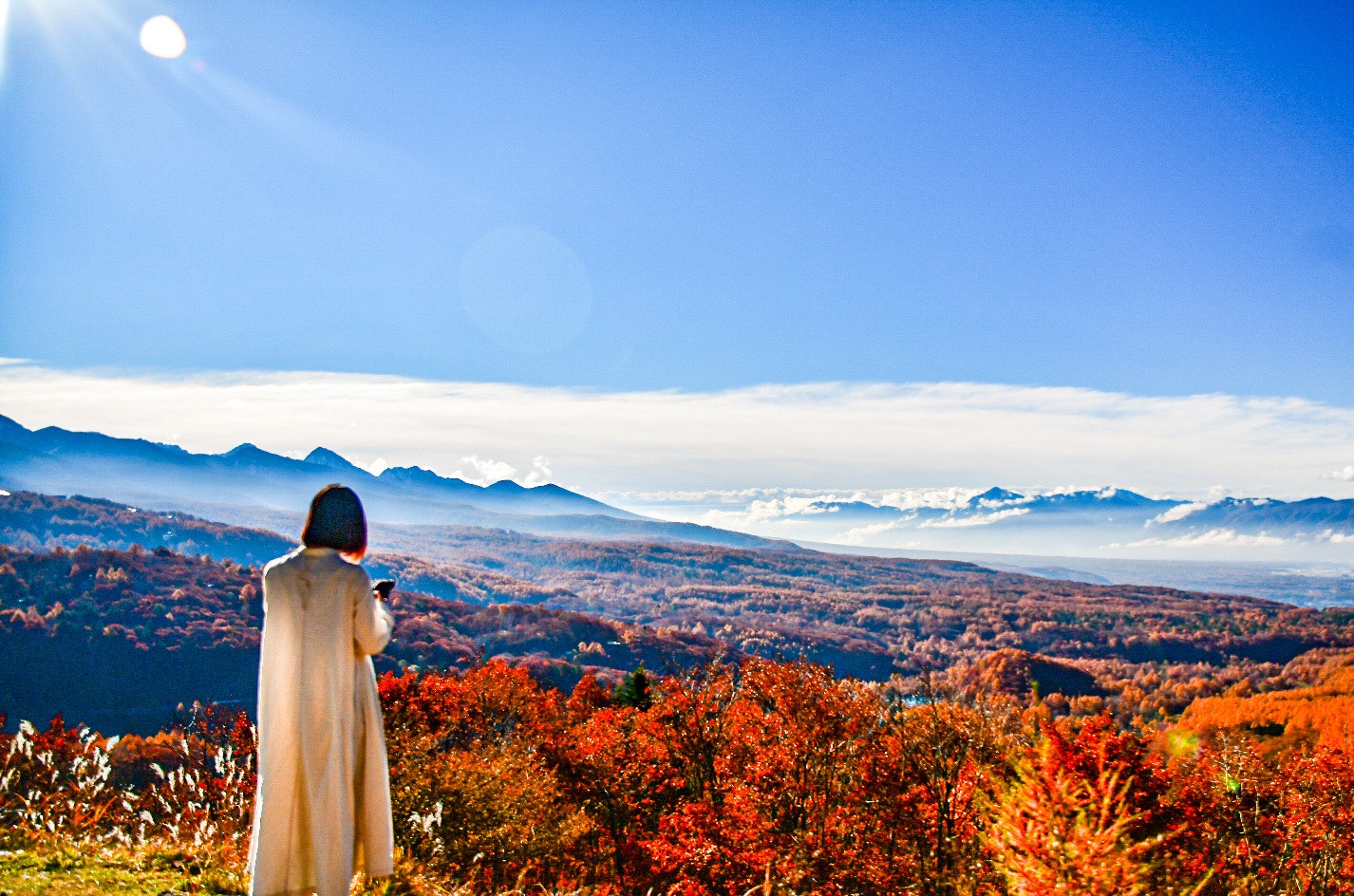 紅葉の丘から見渡す秋の山並みと雲の風景