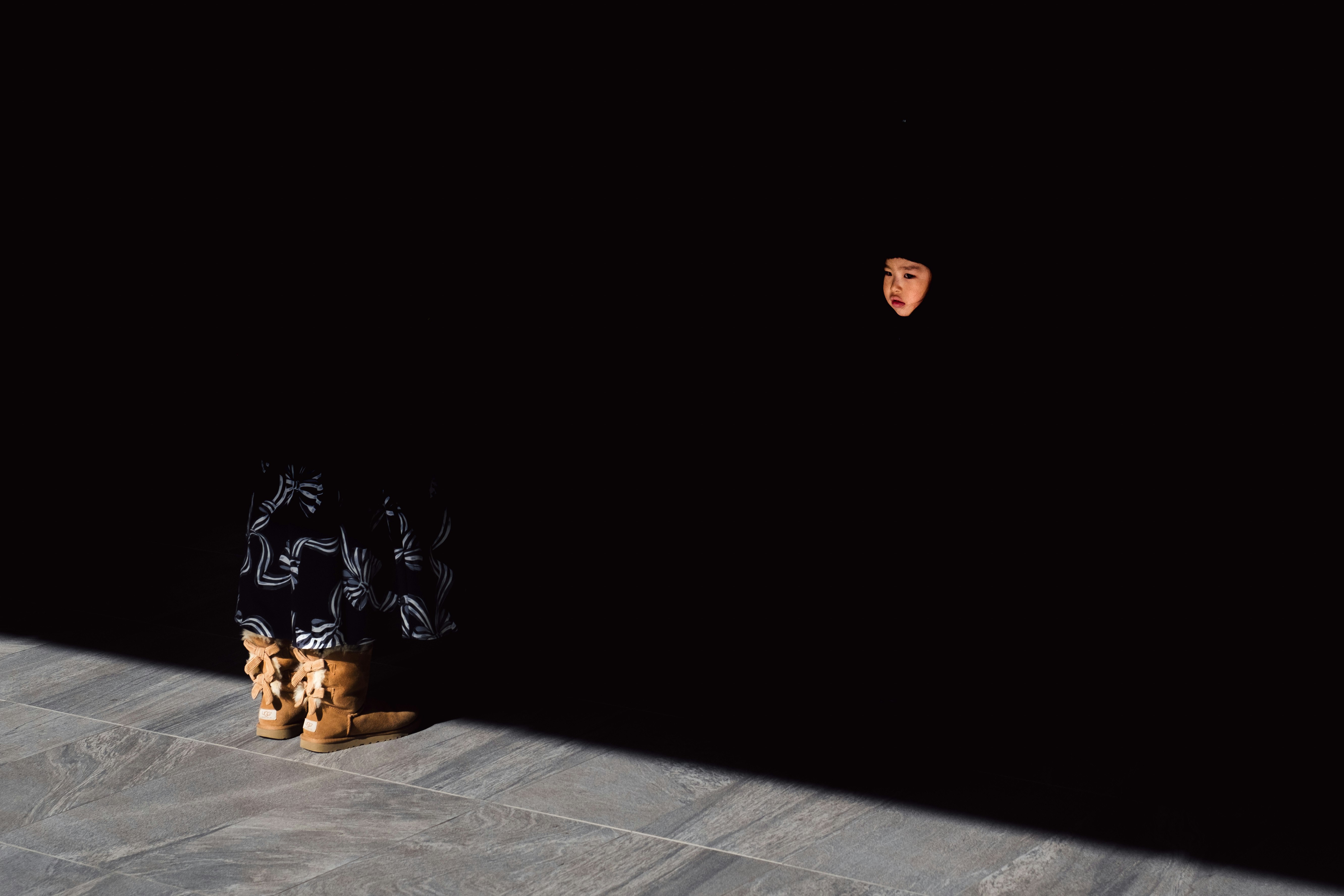 A person standing in a dark space with floor shadows