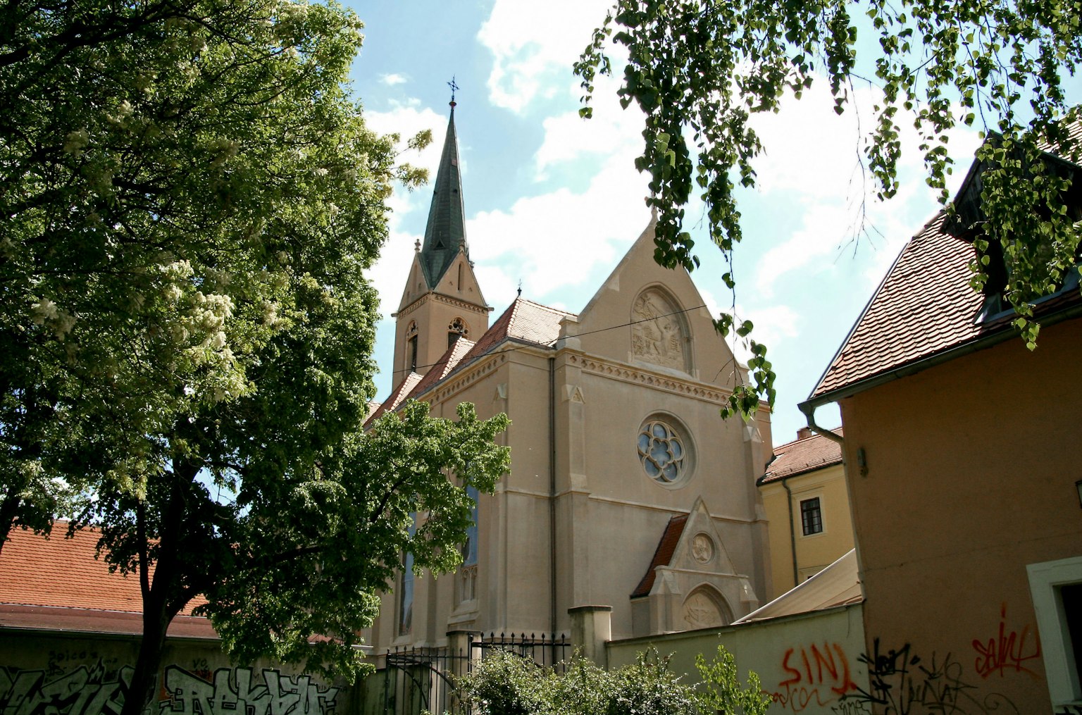 Extérieur d'une église historique sous un ciel bleu avec des arbres verts