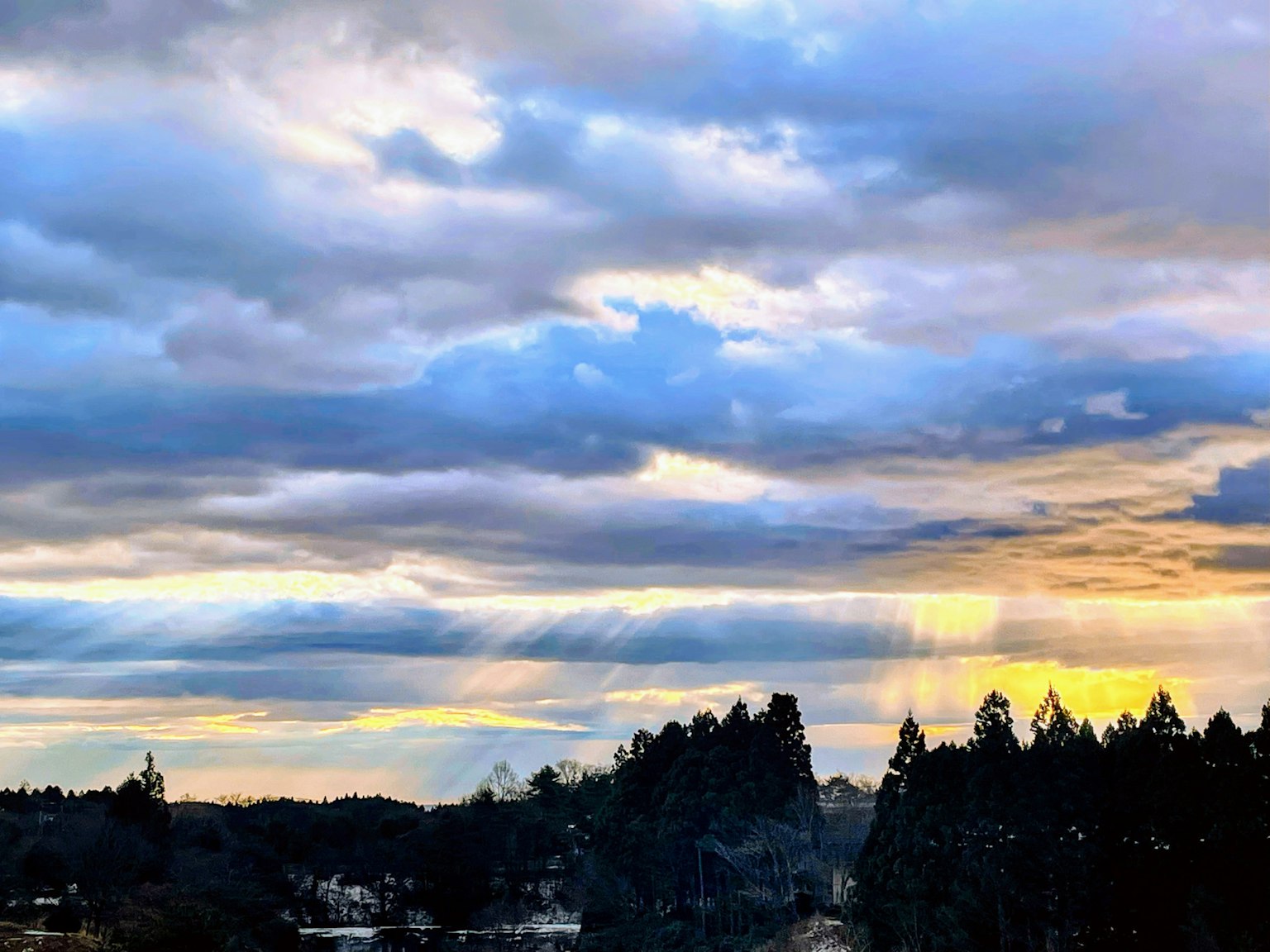 夕陽下的風景 藍天與雲朵 前景中有樹木的輪廓