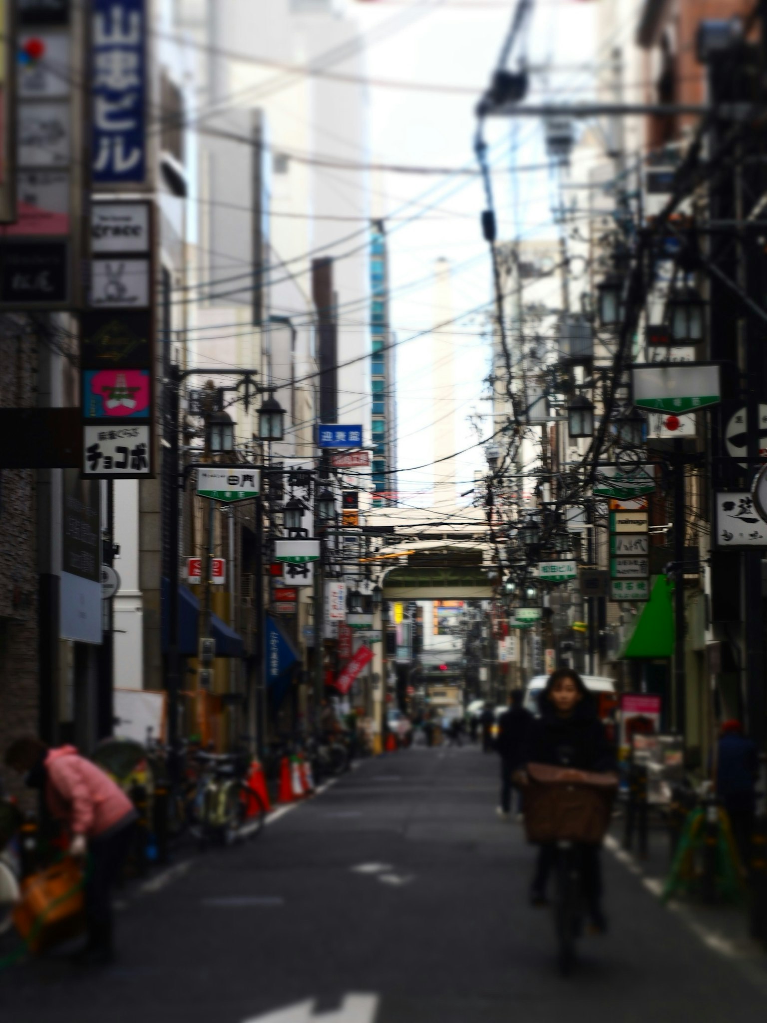 狭窄街道场景有人骑自行车许多标志和电线