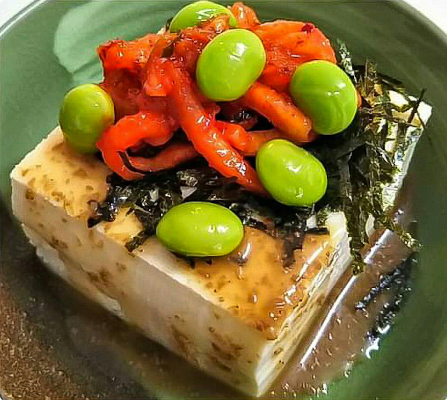 Hidangan dengan tahu yang diberi paprika merah dan edamame hijau