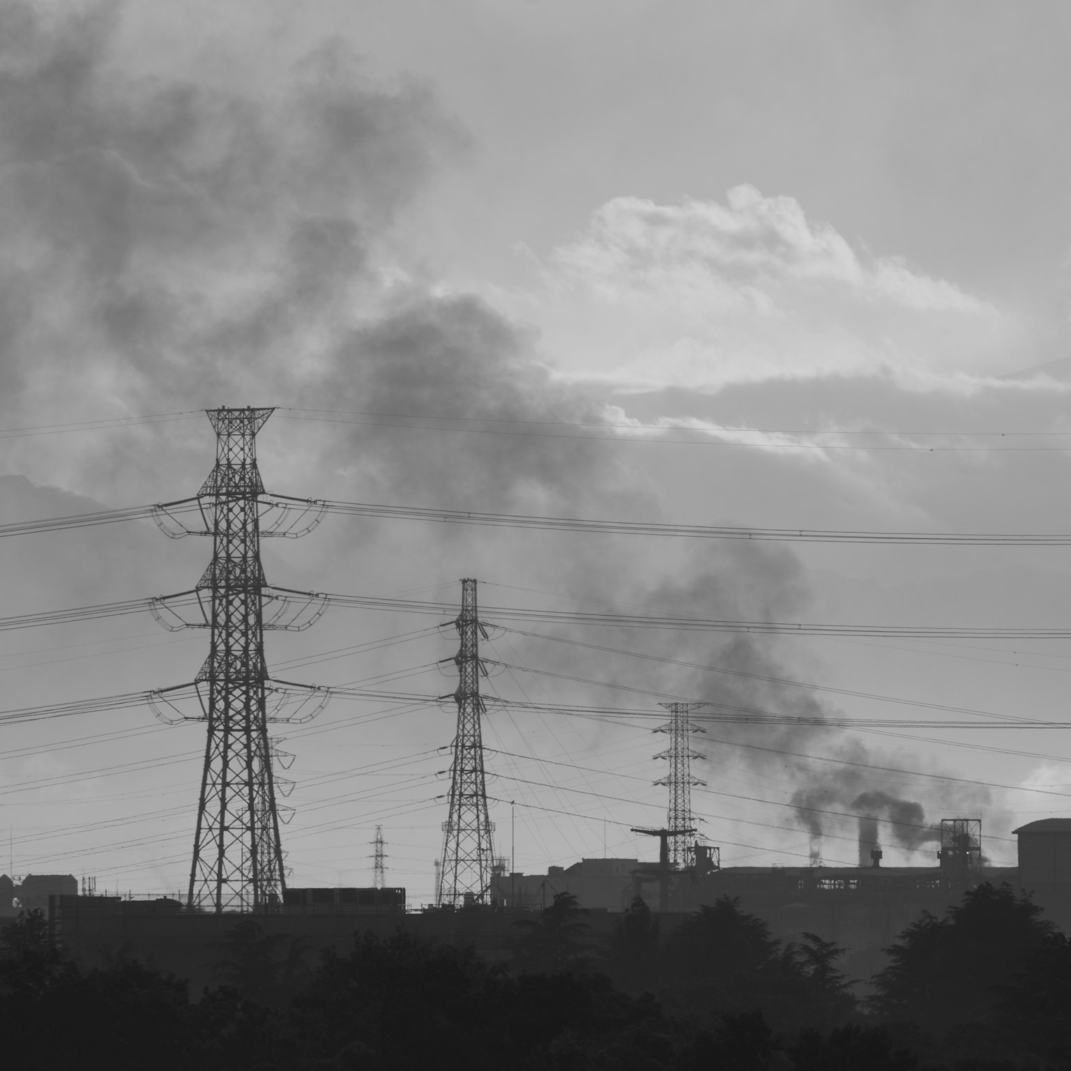黑白風景，煙囪和電線在多雲的天空下