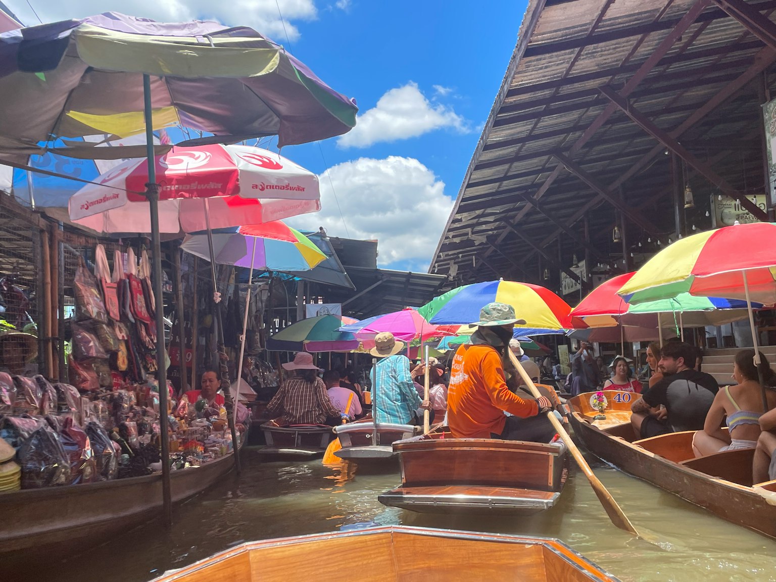 Vibrant scene of a floating market with colorful umbrellas and people in boats