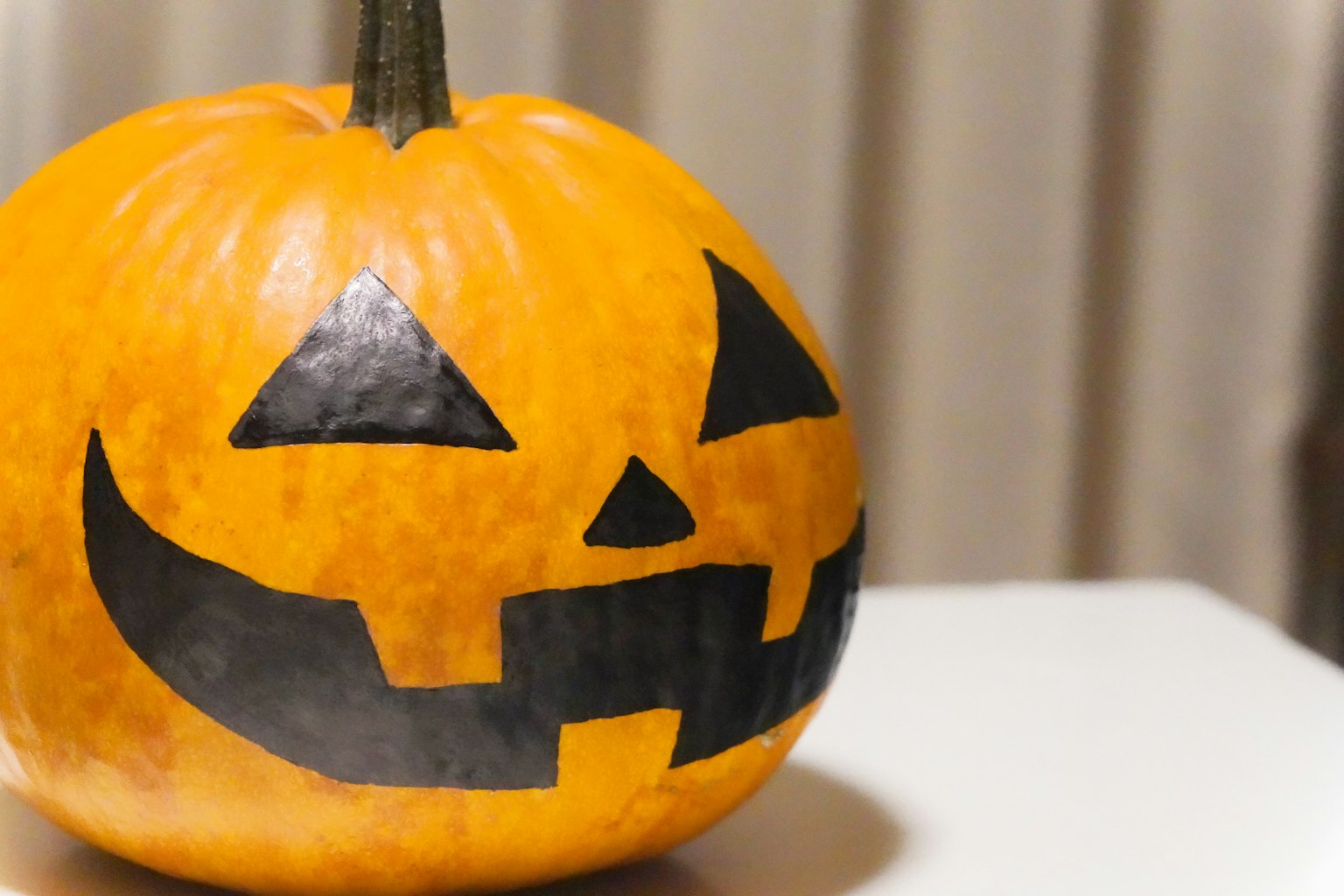 Zucca di Halloween arancione con un design di faccia nera