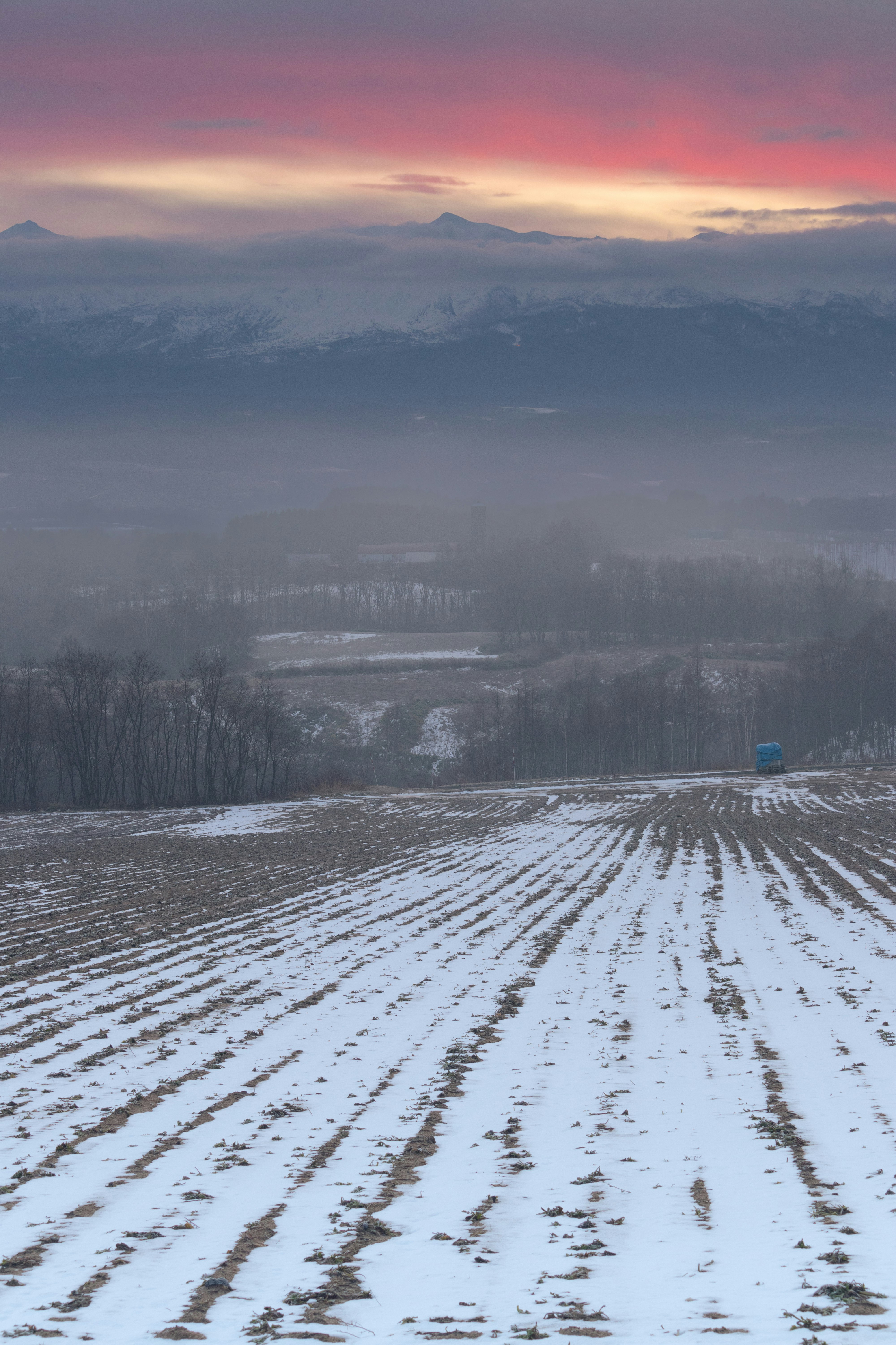 Colline enneigée au lever du jour dans la brume